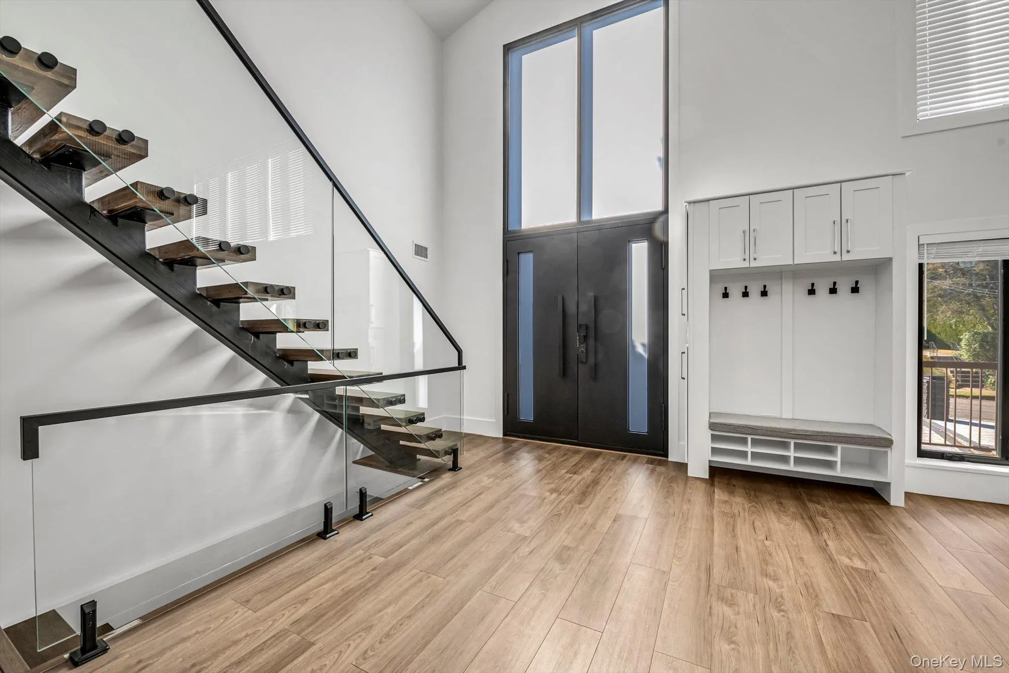 Foyer with stairs, a towering ceiling, and light wood-type flooring Foyer with stairs, a towering ceiling, and light wood-type flooring
