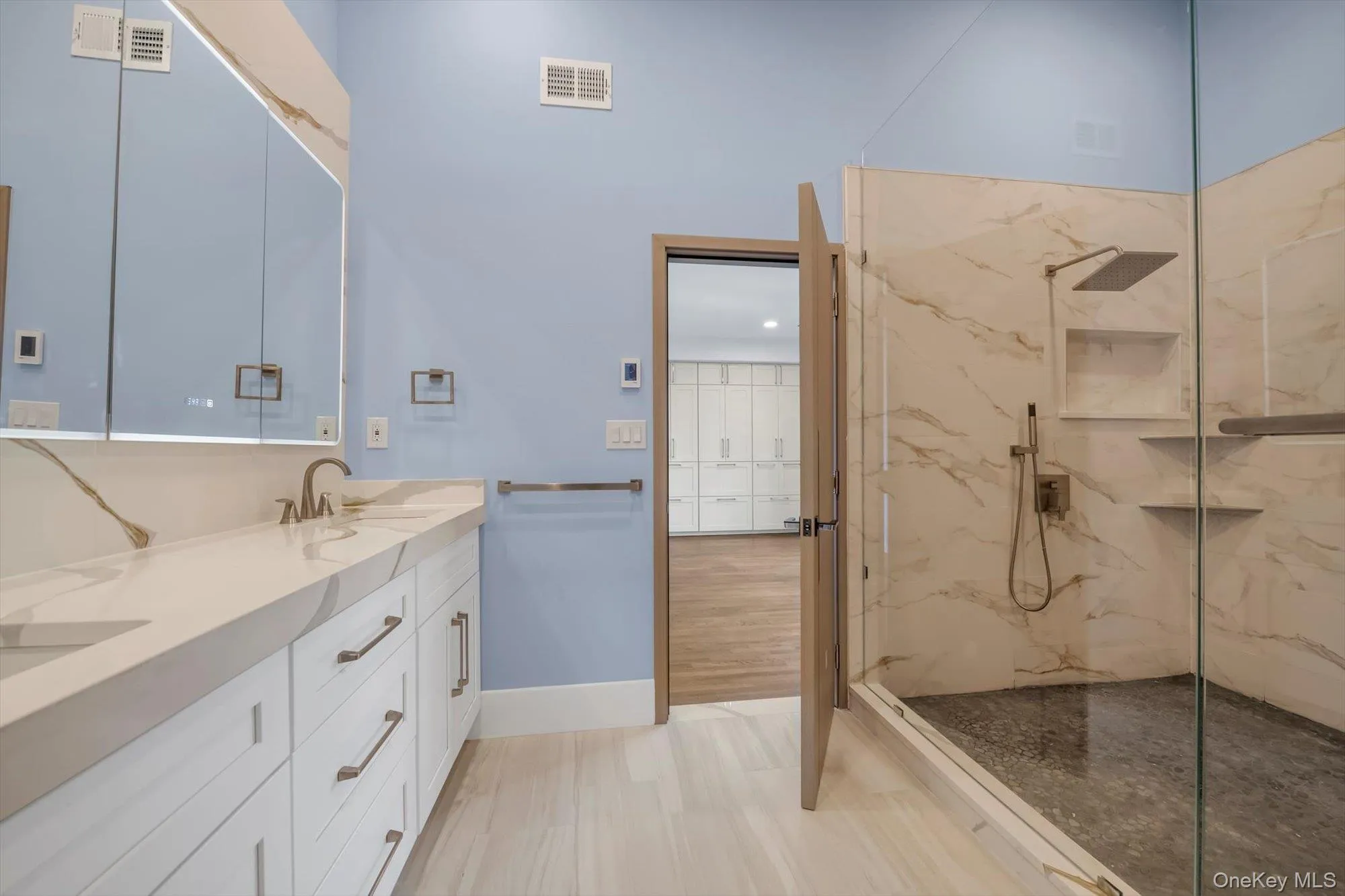 Full bath with double vanity and a marble finish shower Full bath with double vanity and a marble finish shower