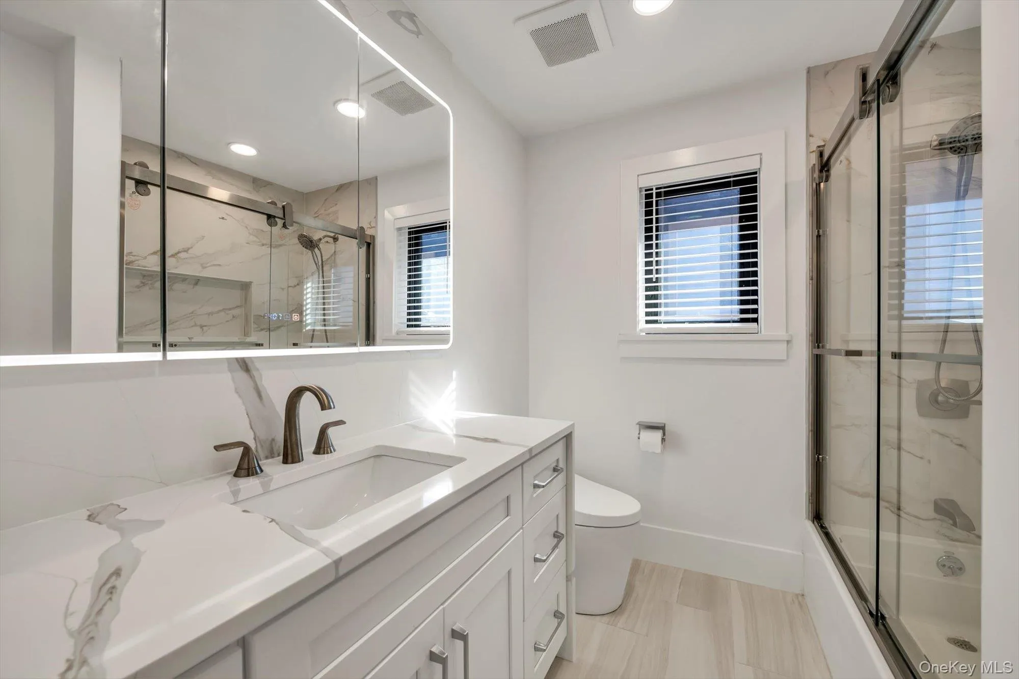 Bathroom with vanity, recessed lighting, and shower / bath combination with glass door Bathroom with vanity, recessed lighting, and shower / bath combination with glass door