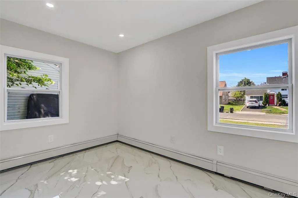 Unfurnished room featuring light marble finish flooring, a baseboard radiator, and recessed lighting Unfurnished room featuring light marble finish flooring, a baseboard radiator, and recessed lighting