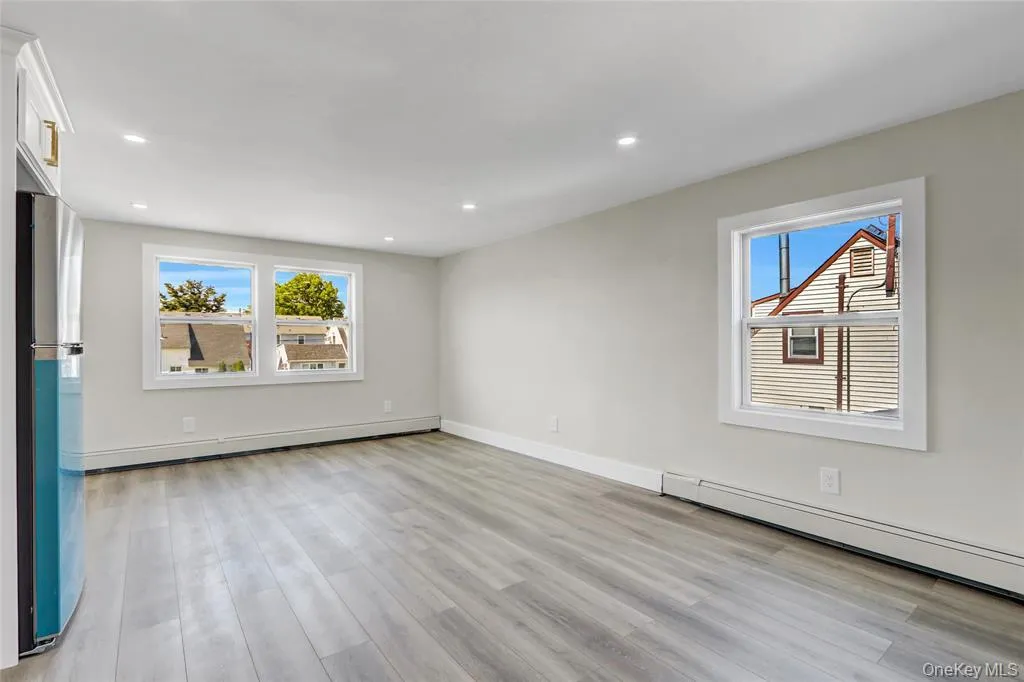 Unfurnished room with light wood finished floors, baseboard heating, and recessed lighting Unfurnished room with light wood finished floors, baseboard heating, and recessed lighting