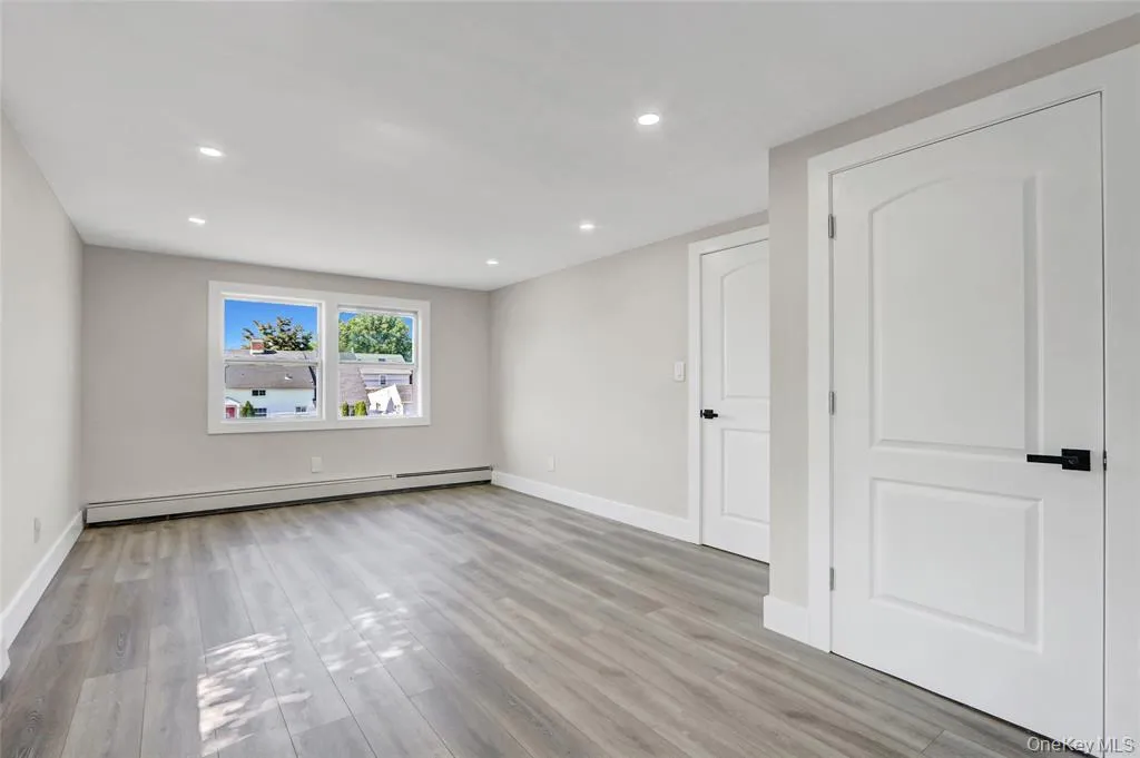 Unfurnished room featuring light wood-type flooring, a baseboard radiator, and recessed lighting Unfurnished room featuring light wood-type flooring, a baseboard radiator, and recessed lighting