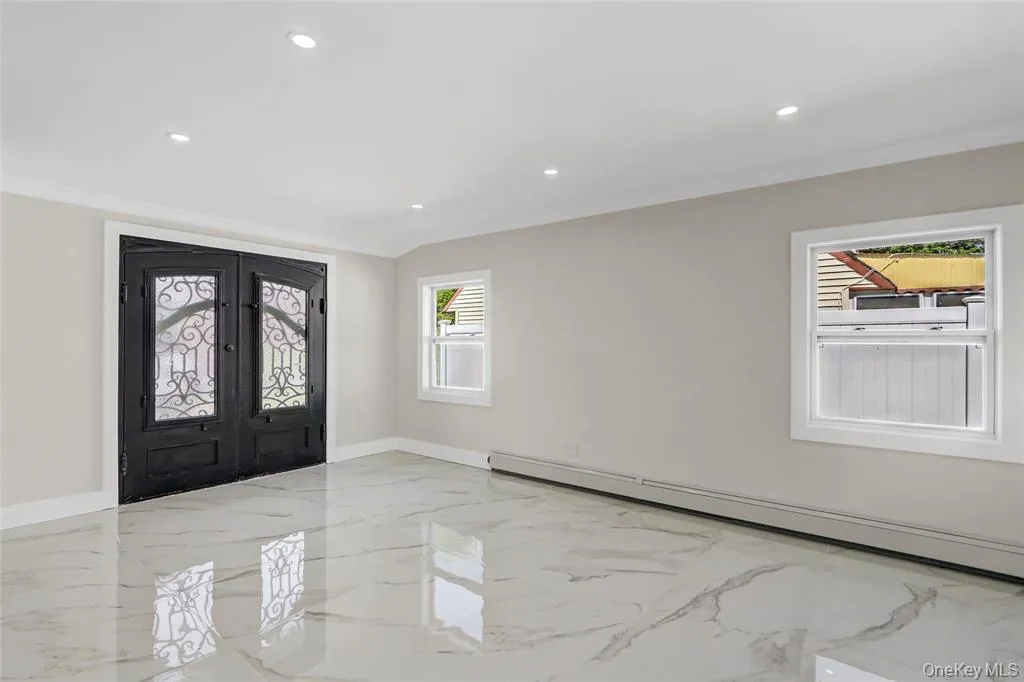 Entrance foyer featuring light marble finish floors, french doors, baseboard heating, recessed lighting, and ornamental molding Entrance foyer featuring light marble finish floors, french doors, baseboard heating, recessed lighting, and ornamental molding