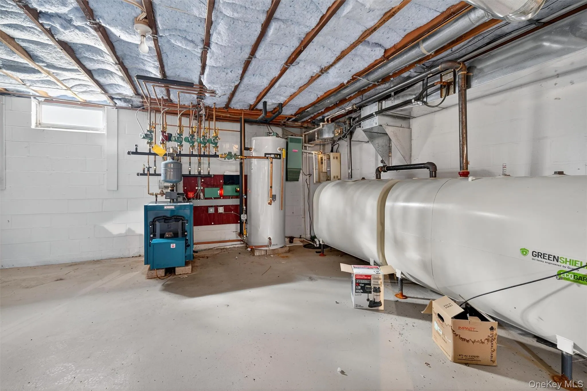 Basement with oil tank, water heater, and a heating unit Basement with oil tank, water heater, and a heating unit