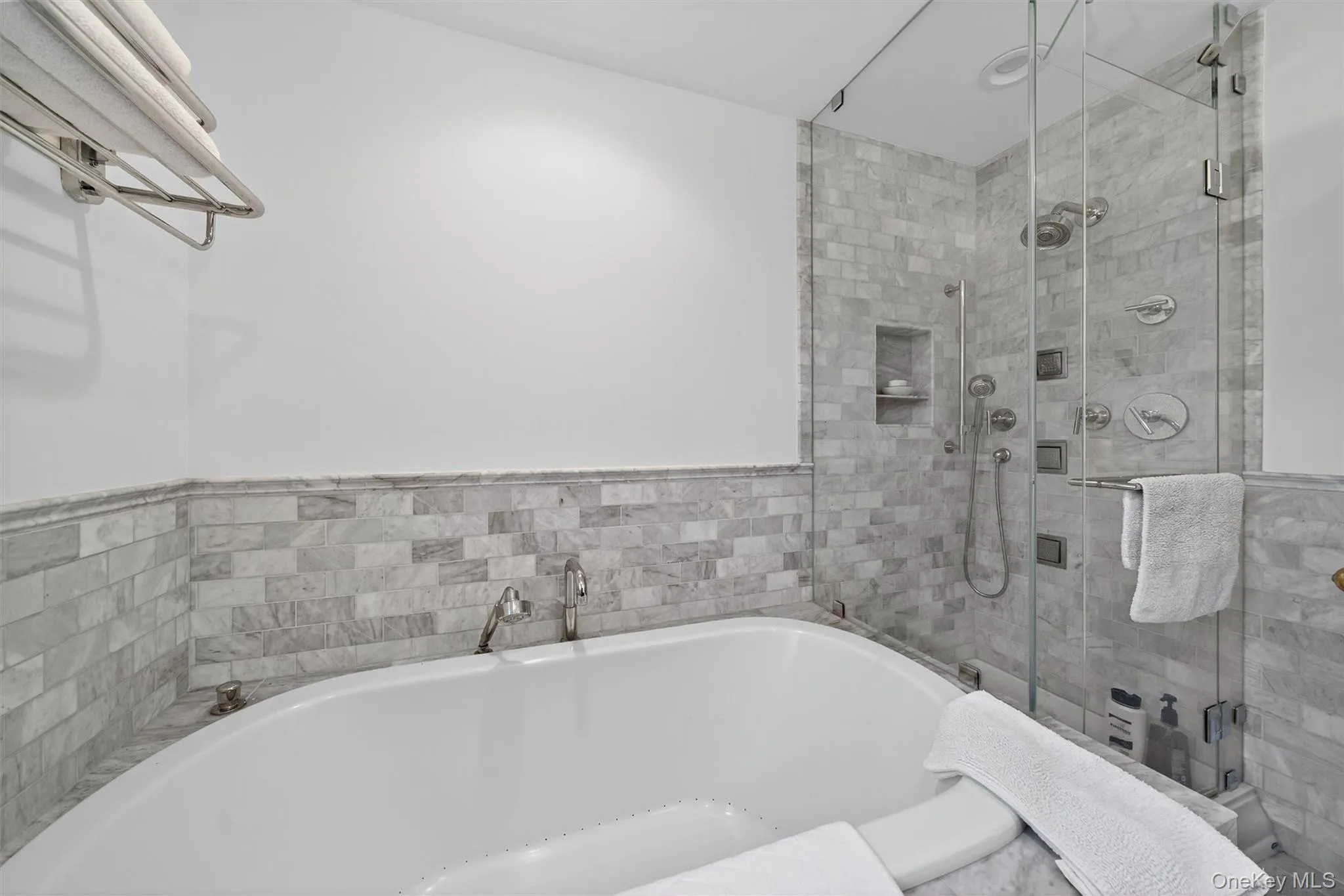 Bathroom featuring a garden tub, a stall shower, and tile walls Bathroom featuring a garden tub, a stall shower, and tile walls