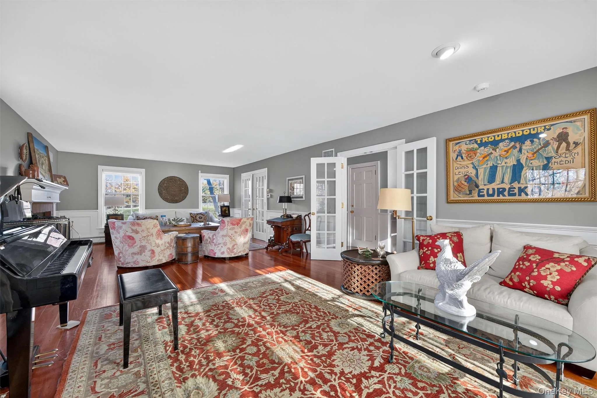Living area featuring hardwood / wood-style flooring, a wainscoted wall, french doors, and a decorative wall Living area featuring hardwood / wood-style flooring, a wainscoted wall, french doors, and a decorative wall
