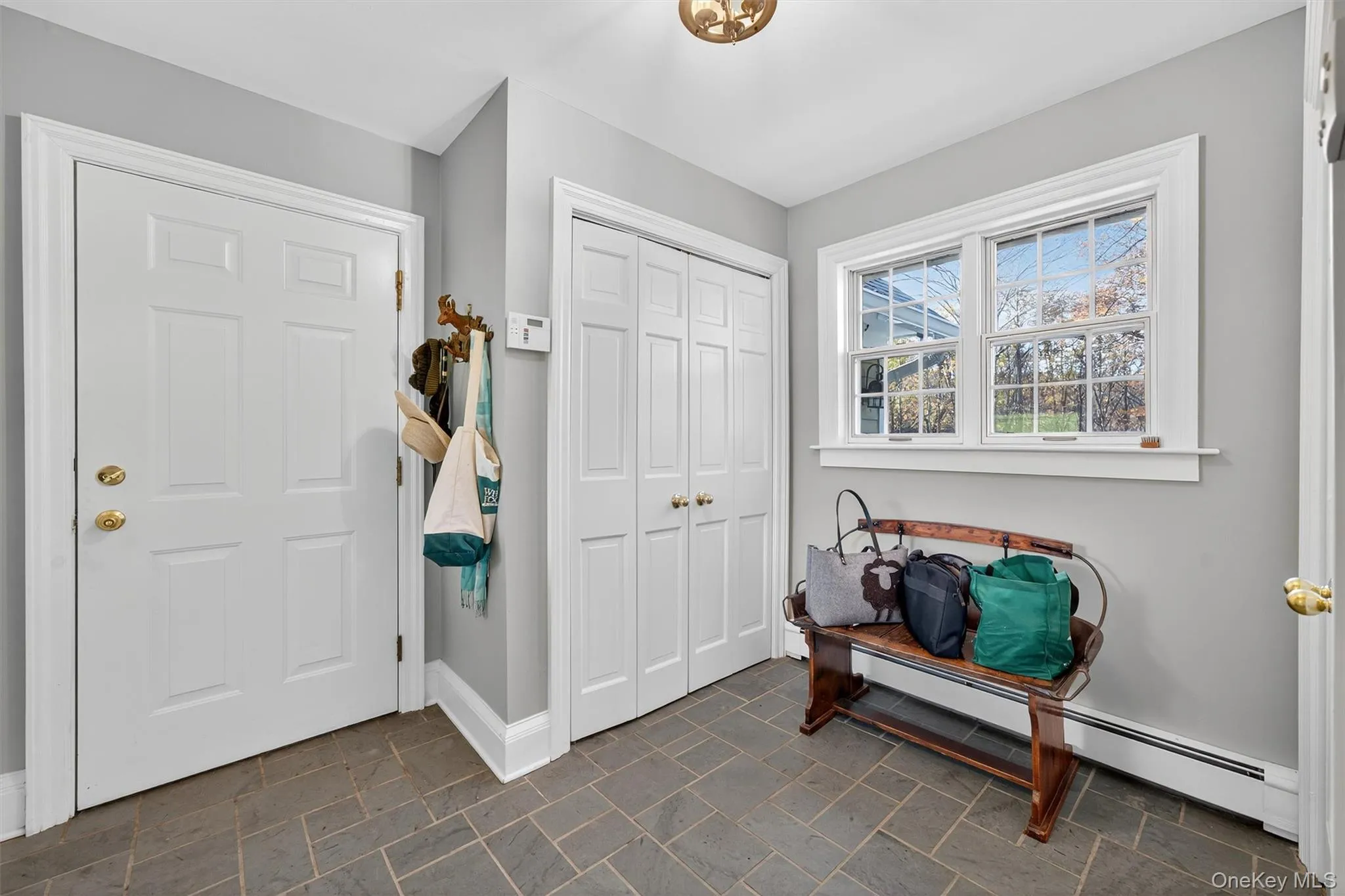 Foyer entrance featuring a baseboard radiator and dark stone finish flooring Foyer entrance featuring a baseboard radiator and dark stone finish flooring