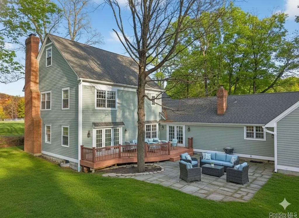 Back of property featuring a patio, an outdoor living space, a chimney, and a lawn Back of property featuring a patio, an outdoor living space, a chimney, and a lawn