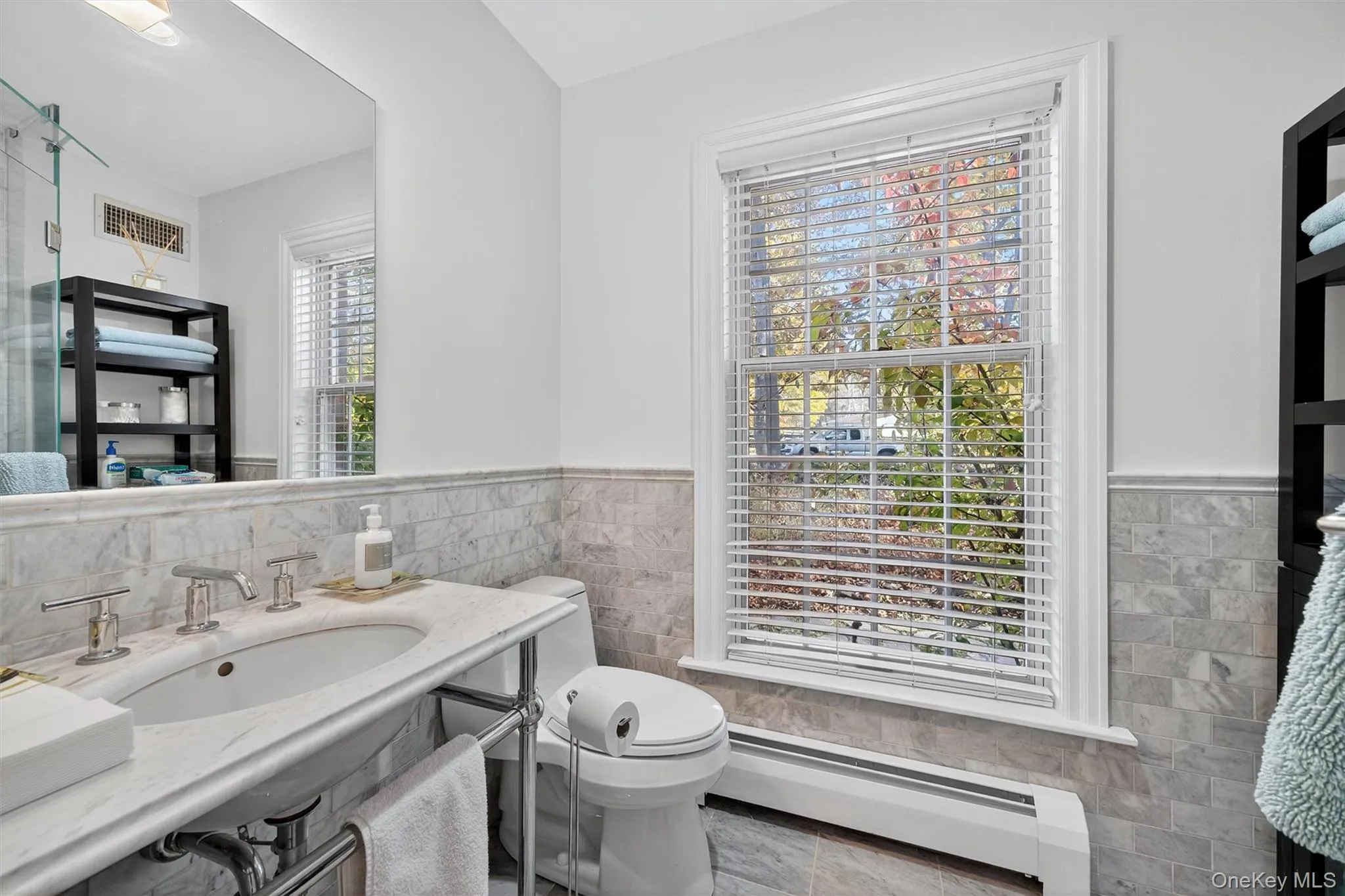 Bathroom featuring tile walls, a baseboard heating unit, wainscoting, and vanity Bathroom featuring tile walls, a baseboard heating unit, wainscoting, and vanity