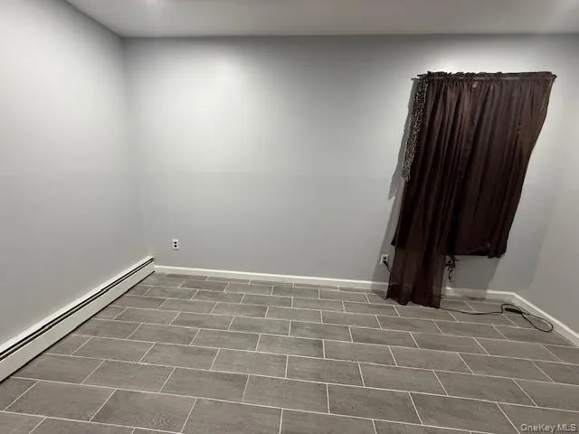 Empty room with a baseboard radiator and baseboards Empty room with a baseboard radiator and baseboards