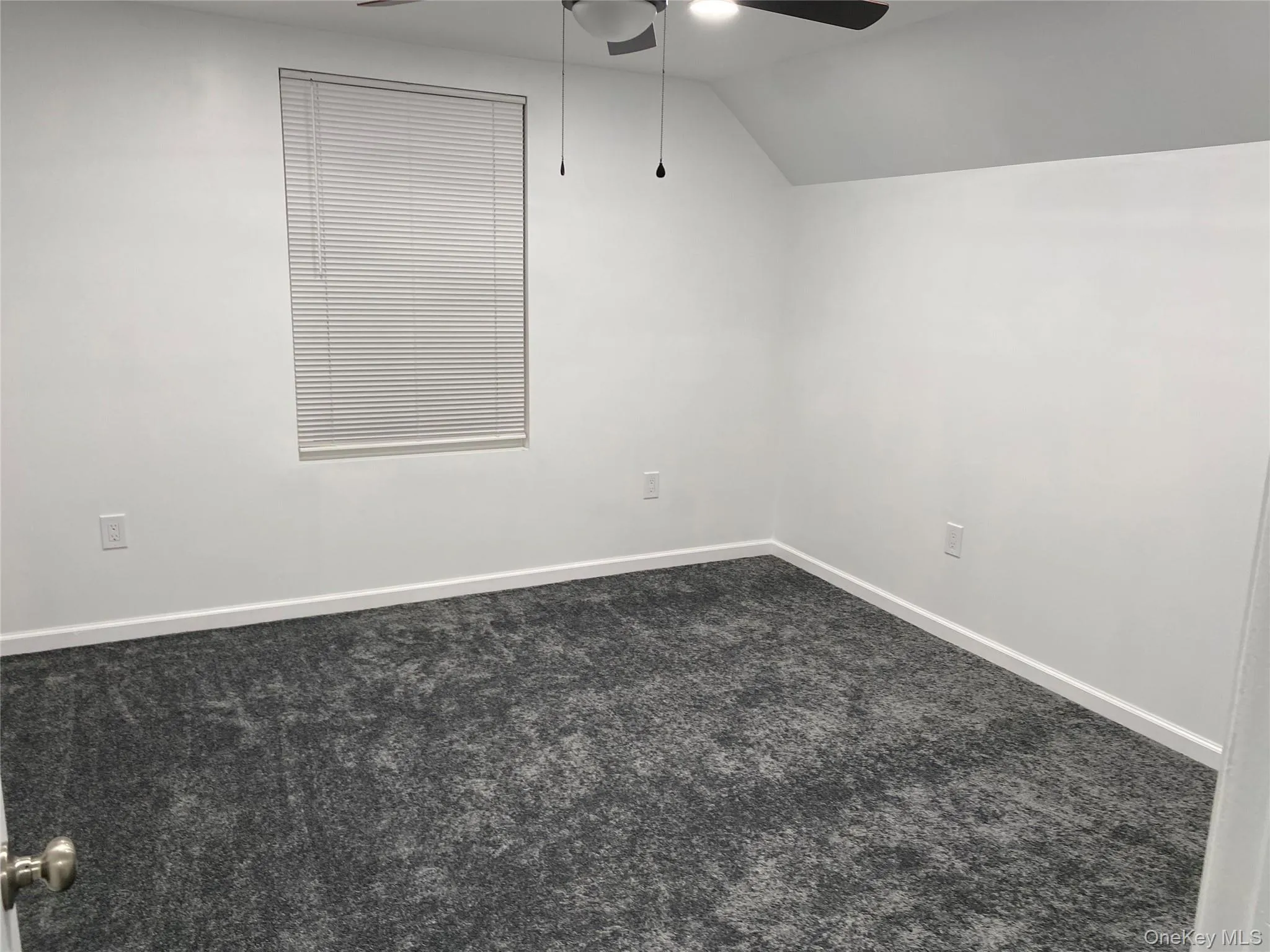 Bonus room with dark carpet, vaulted ceiling, and a ceiling fan Bonus room with dark carpet, vaulted ceiling, and a ceiling fan