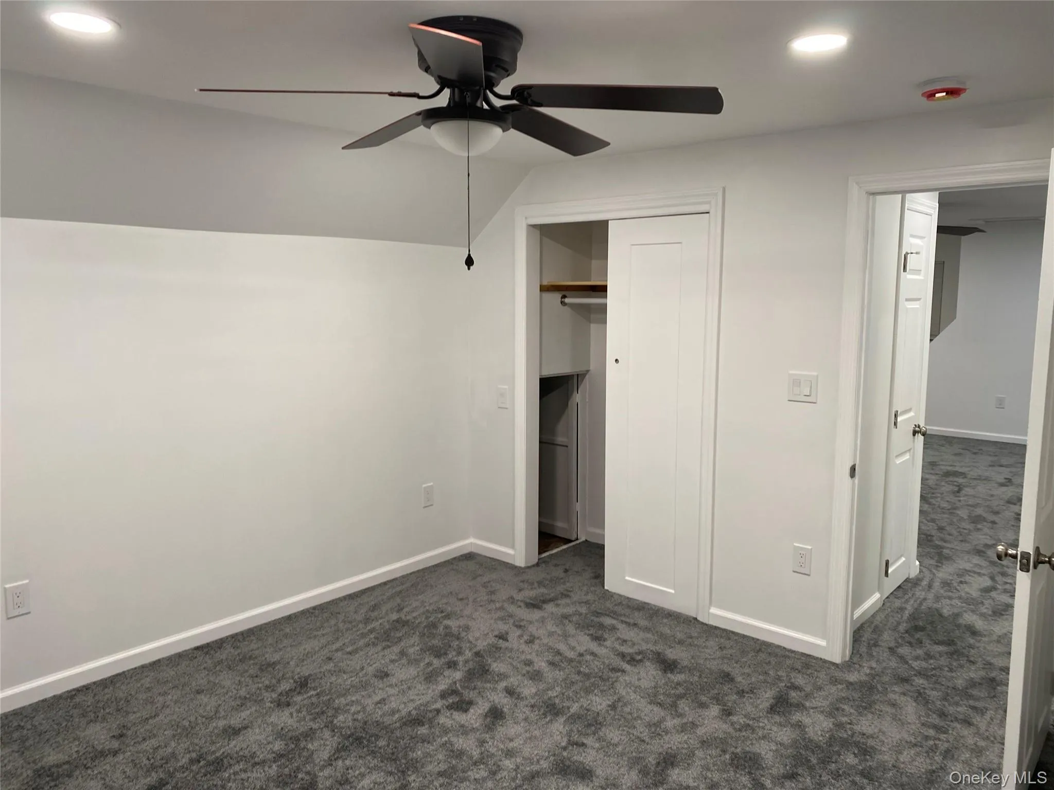 Unfurnished bedroom featuring recessed lighting, dark colored carpet, vaulted ceiling, and a ceiling fan Unfurnished bedroom featuring recessed lighting, dark colored carpet, vaulted ceiling, and a ceiling fan