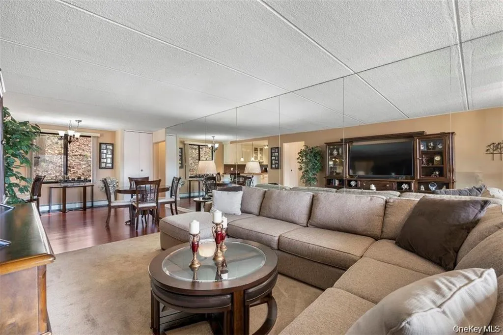 Living area with a chandelier, wood finished floors, and a textured ceiling Living area with a chandelier, wood finished floors, and a textured ceiling