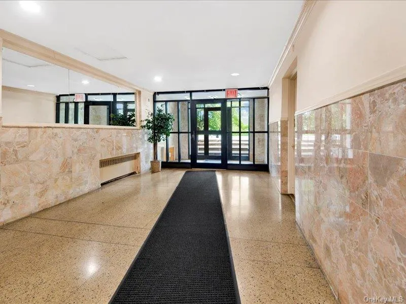 Lobby featuring tile walls, recessed lighting, floor to ceiling windows, and crown molding Lobby featuring tile walls, recessed lighting, floor to ceiling windows, and crown molding