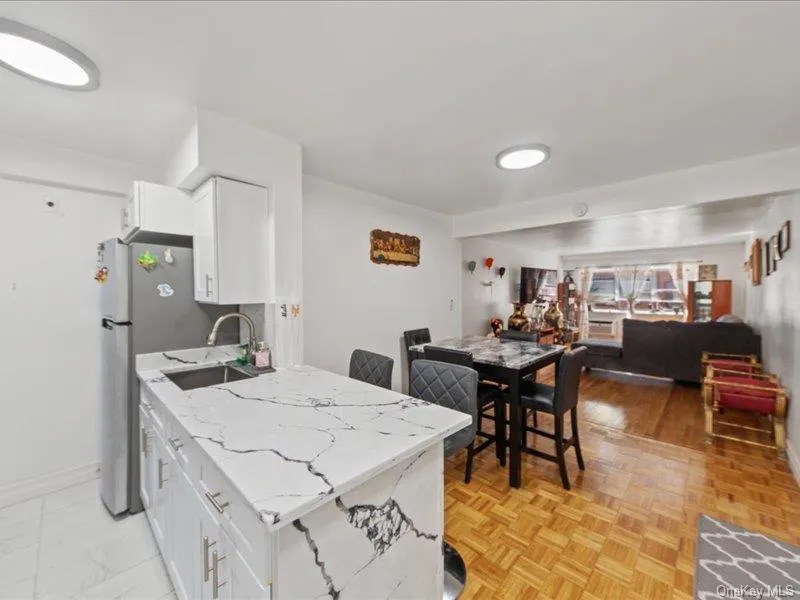 Kitchen with open floor plan, white cabinets, light stone counters, and a peninsula Kitchen with open floor plan, white cabinets, light stone counters, and a peninsula