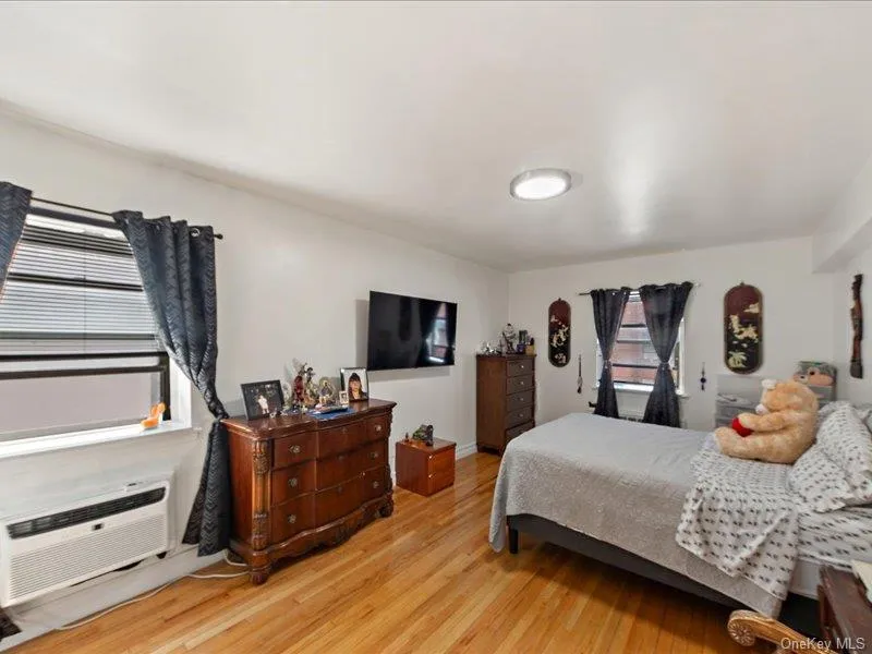 Bedroom with light wood-type flooring and a wall mounted AC Bedroom with light wood-type flooring and a wall mounted AC