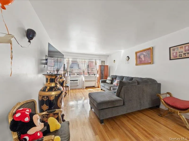 Living room featuring light wood-style flooring and radiator heating unit Living room featuring light wood-style flooring and radiator heating unit