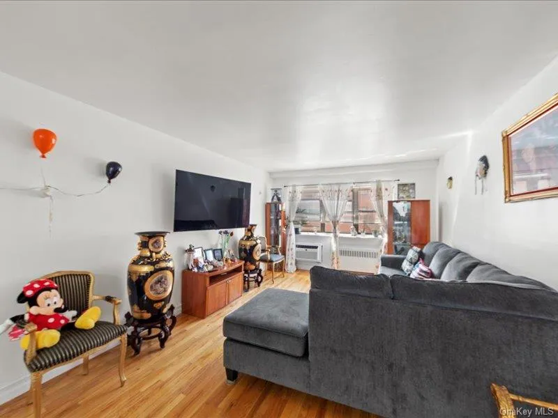Living area featuring wood finished floors and radiator heating unit Living area featuring wood finished floors and radiator heating unit