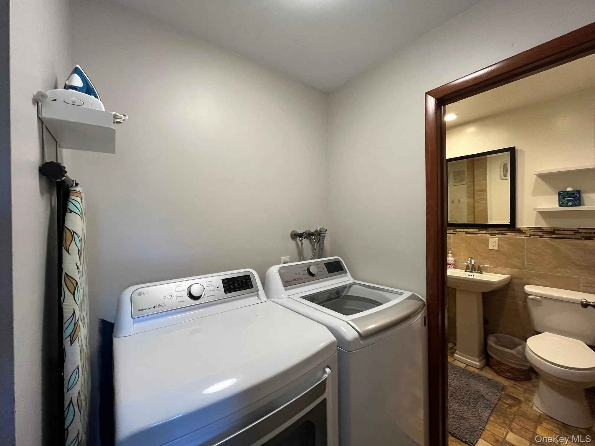 Washroom with tile walls and washer and clothes dryer Washroom with tile walls and washer and clothes dryer