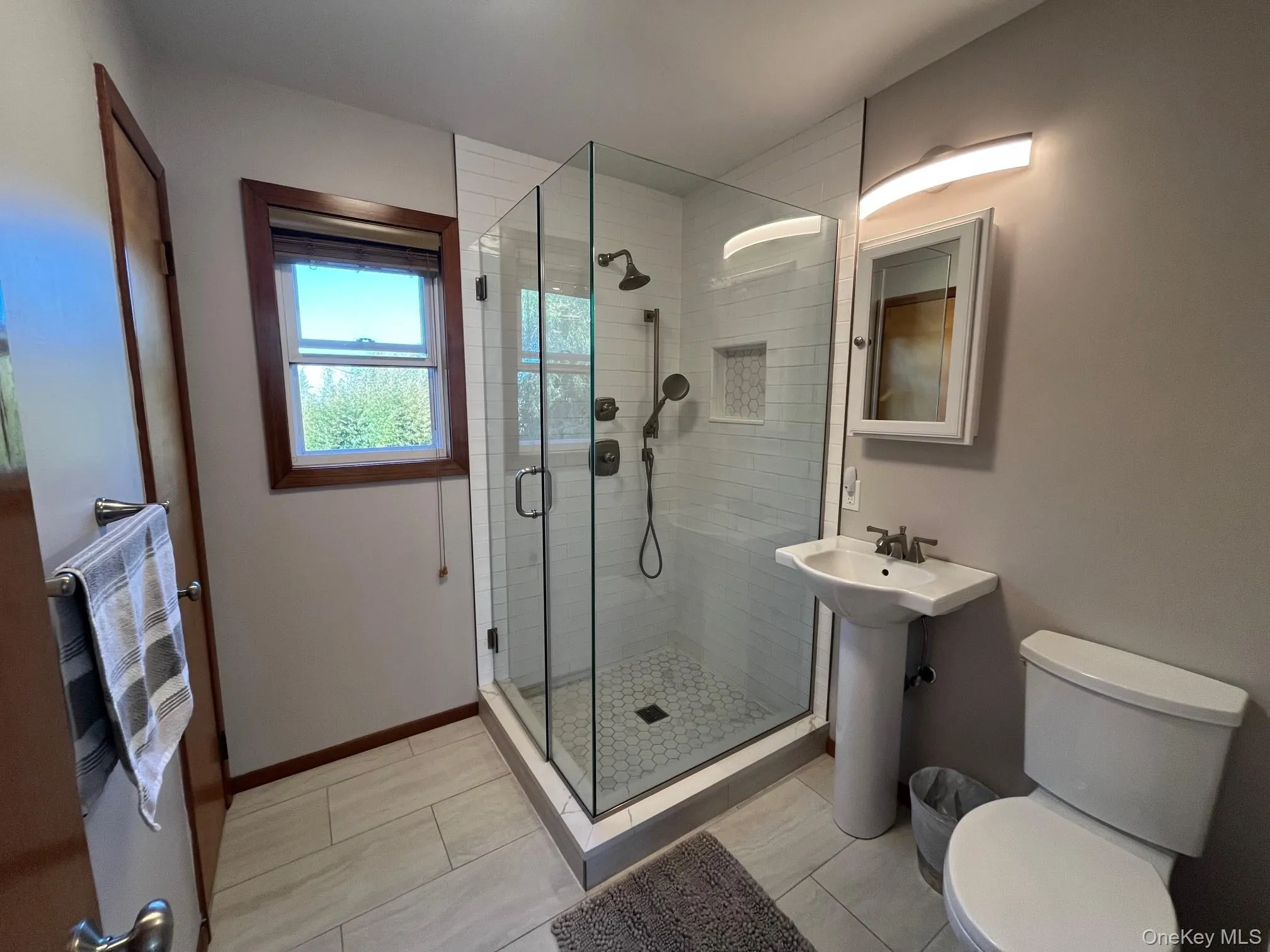 Bathroom featuring a shower stall and light tile patterned floors Bathroom featuring a shower stall and light tile patterned floors