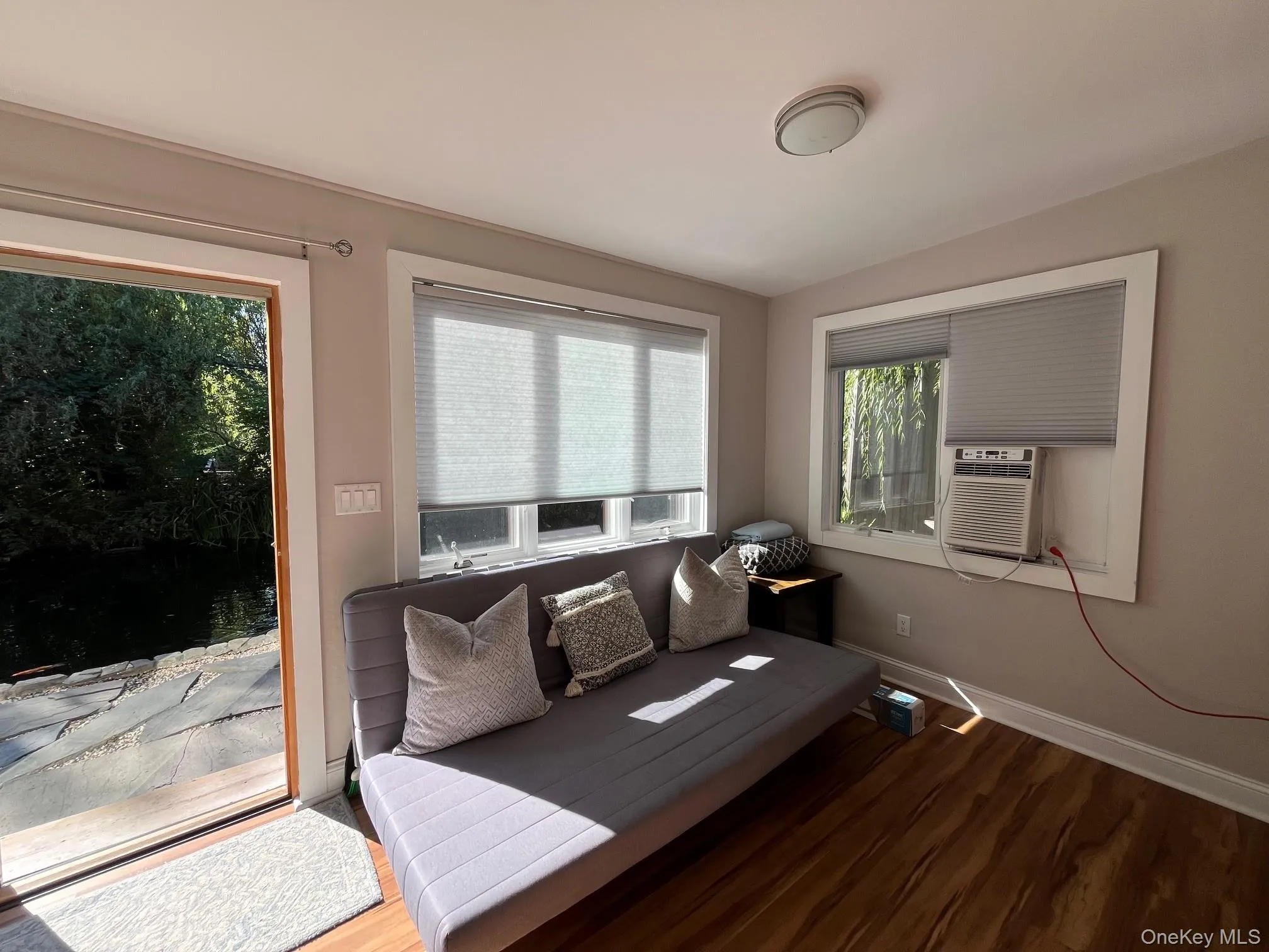 Sitting room featuring wood finished floors and cooling unit Sitting room featuring wood finished floors and cooling unit