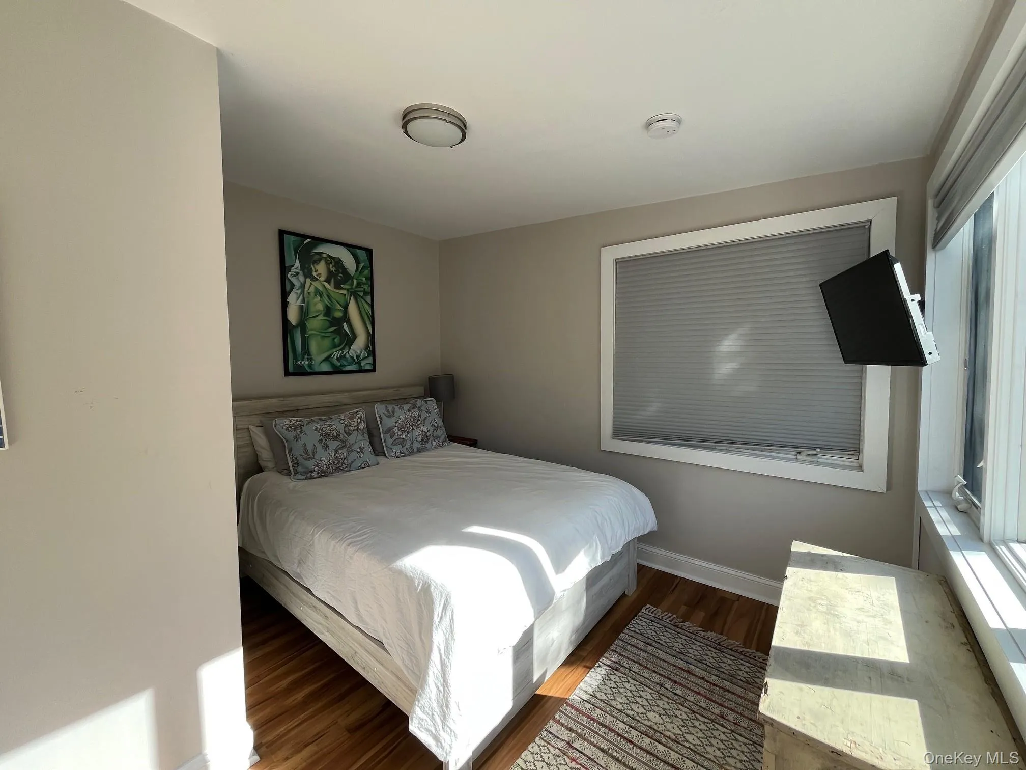 Bedroom featuring wood finished floors and baseboards Bedroom featuring wood finished floors and baseboards