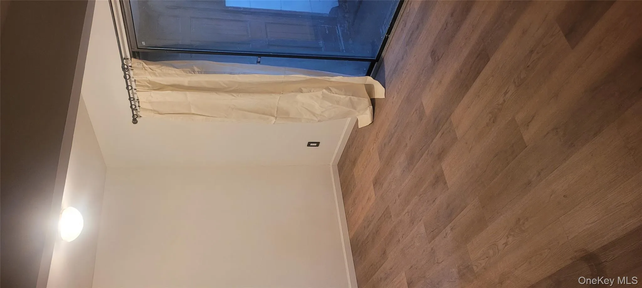 Spare room featuring baseboards and dark wood-style flooring Spare room featuring baseboards and dark wood-style flooring