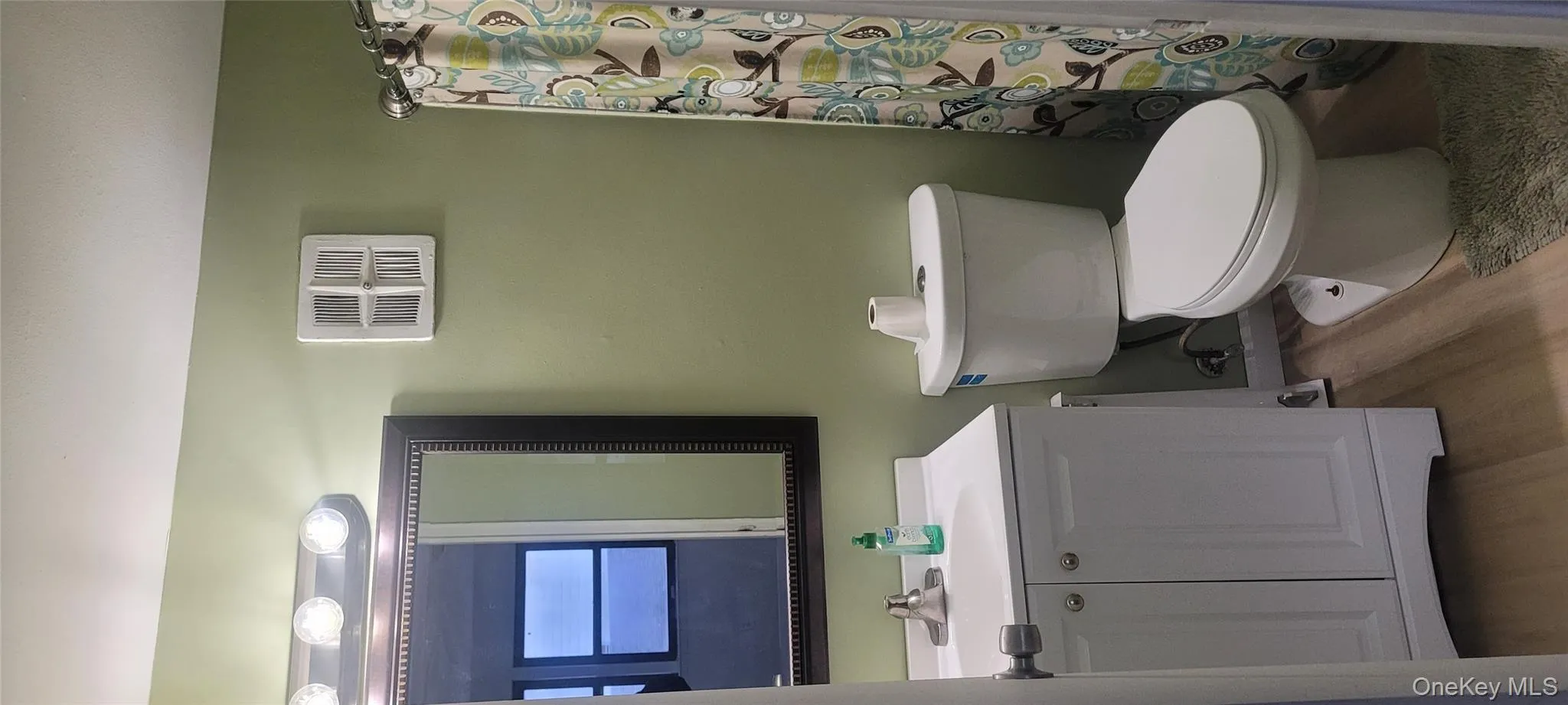 Bathroom with light wood finished floors, vanity, and a shower with curtain Bathroom with light wood finished floors, vanity, and a shower with curtain