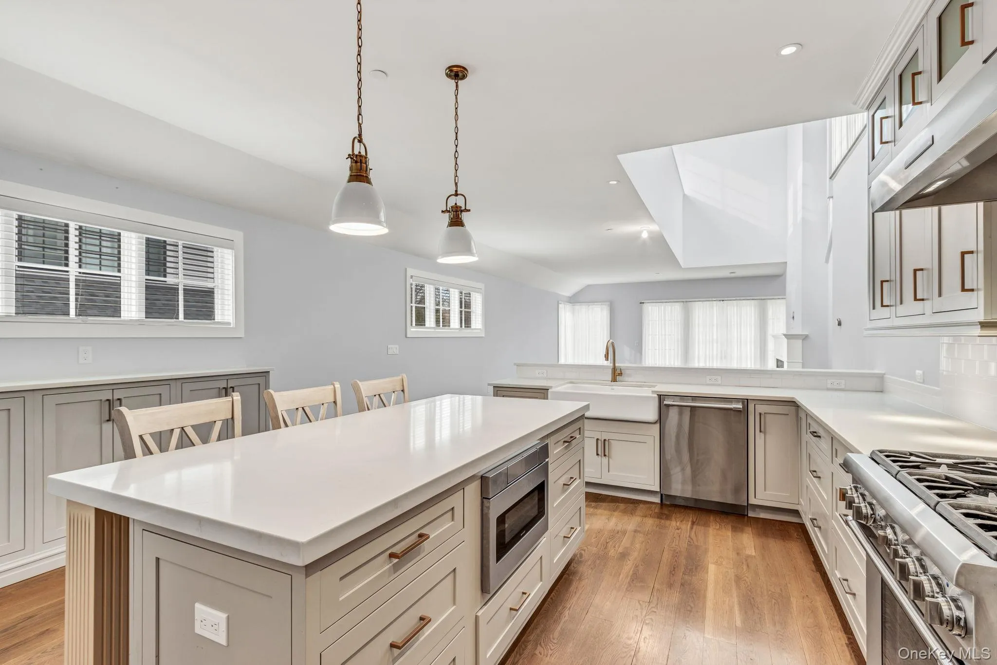 Kitchen with stainless steel appliances, hanging light fixtures, recessed lighting, light wood-style floors, and ventilation hood Kitchen with stainless steel appliances, hanging light fixtures, recessed lighting, light wood-style floors, and ventilation hood