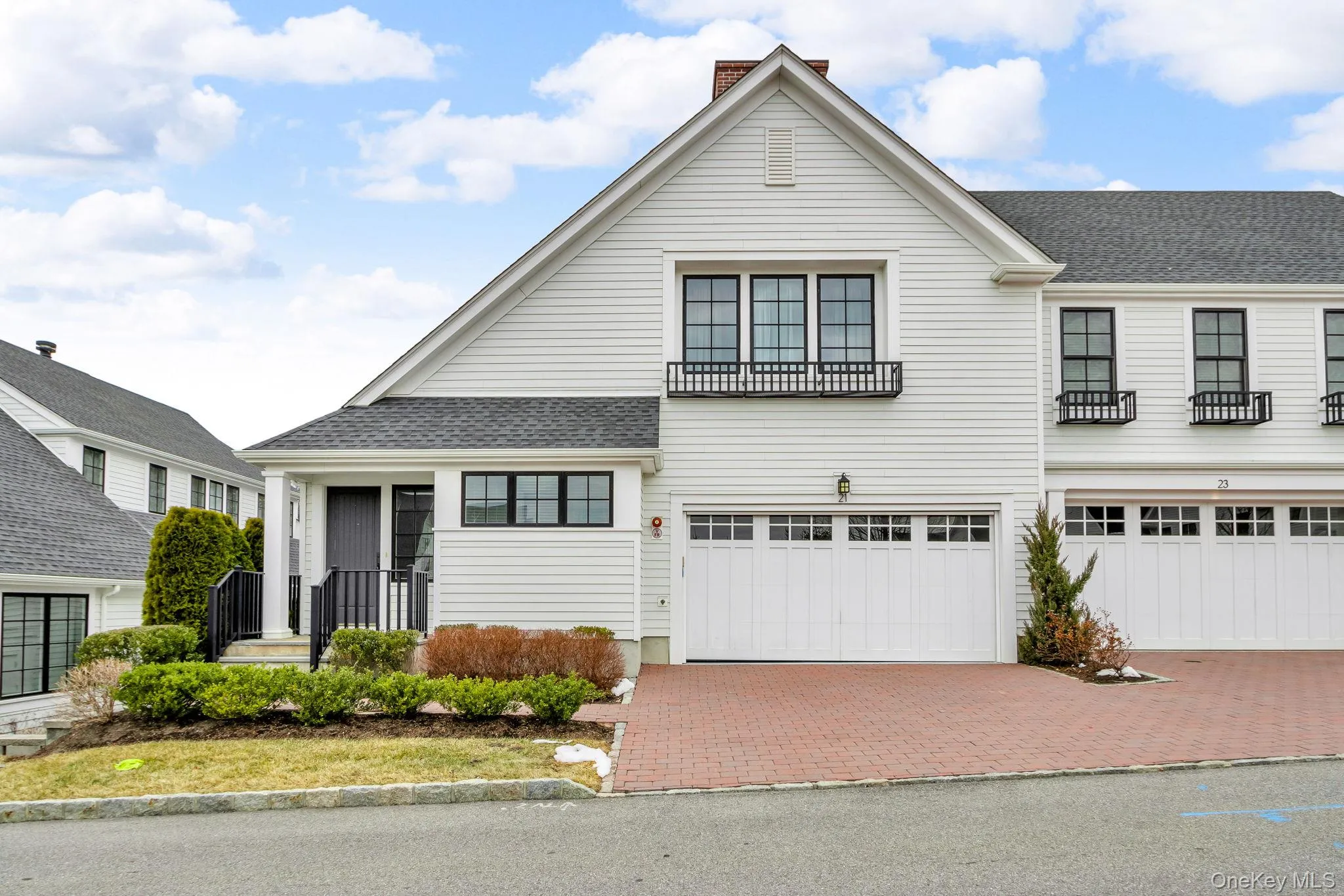 View of front of house with decorative driveway, an attached garage, a chimney, and roof with shingles View of front of house with decorative driveway, an attached garage, a chimney, and roof with shingles