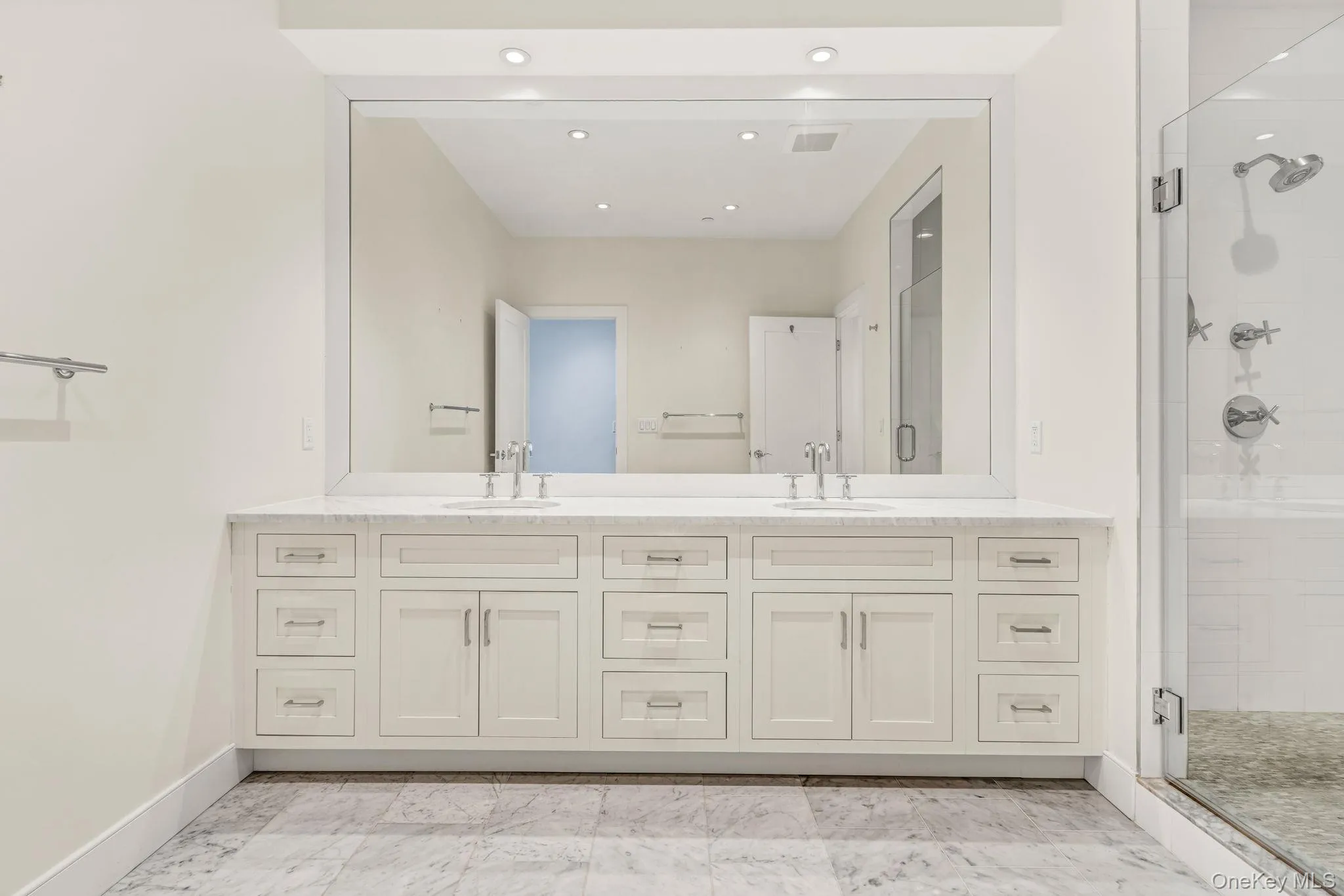 Full bath featuring a stall shower, double vanity, recessed lighting, and light marble finish floors Full bath featuring a stall shower, double vanity, recessed lighting, and light marble finish floors