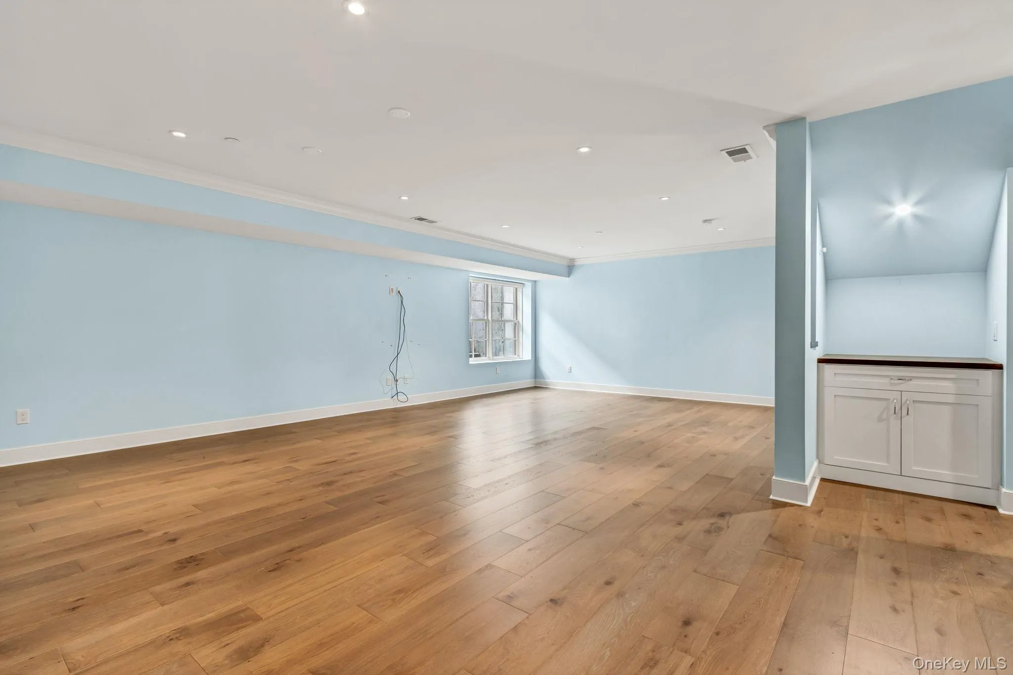 Unfurnished living room featuring light wood-style floors, ornamental molding, and recessed lighting Unfurnished living room featuring light wood-style floors, ornamental molding, and recessed lighting