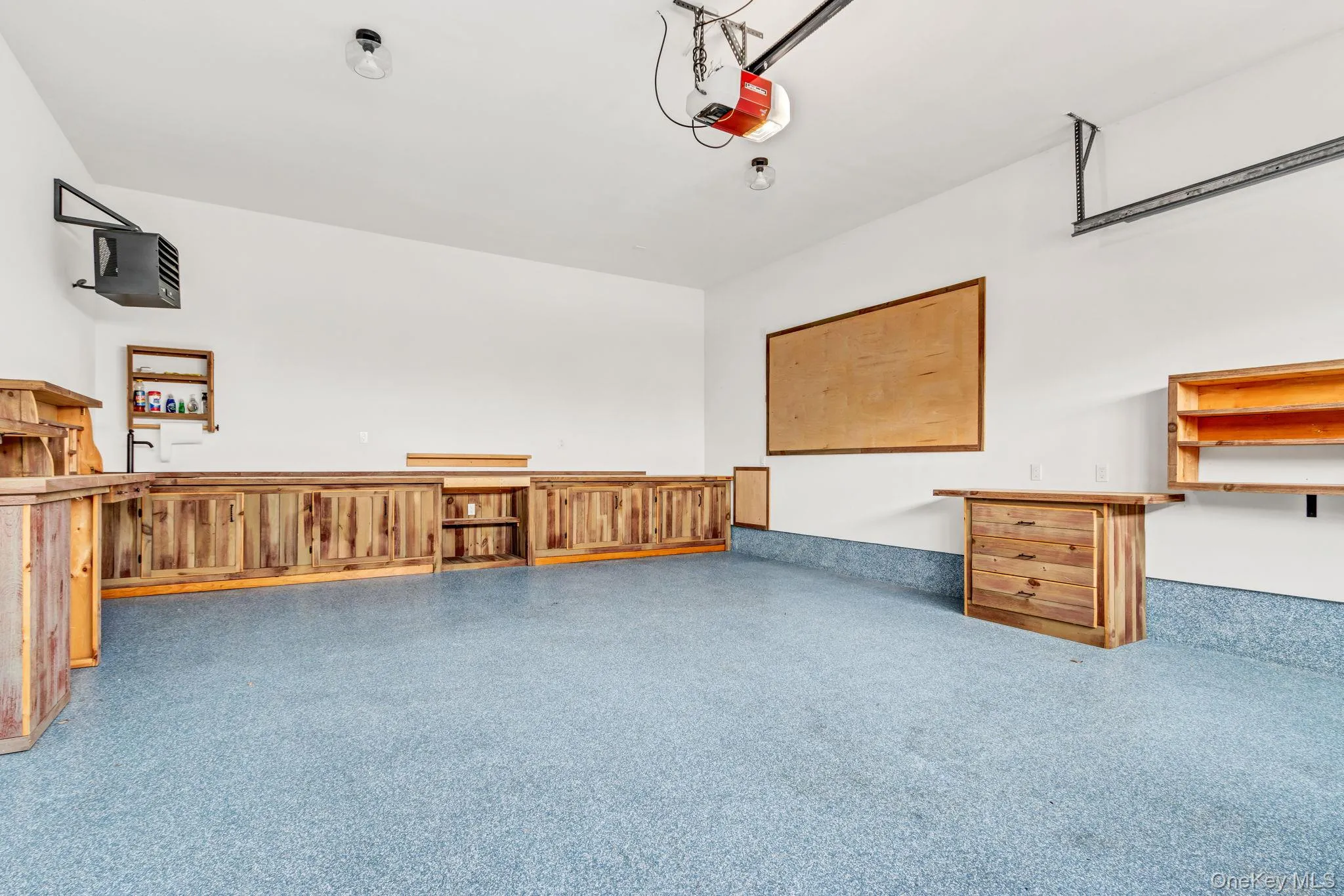 Garage featuring a heating unit and a garage door opener Garage featuring a heating unit and a garage door opener