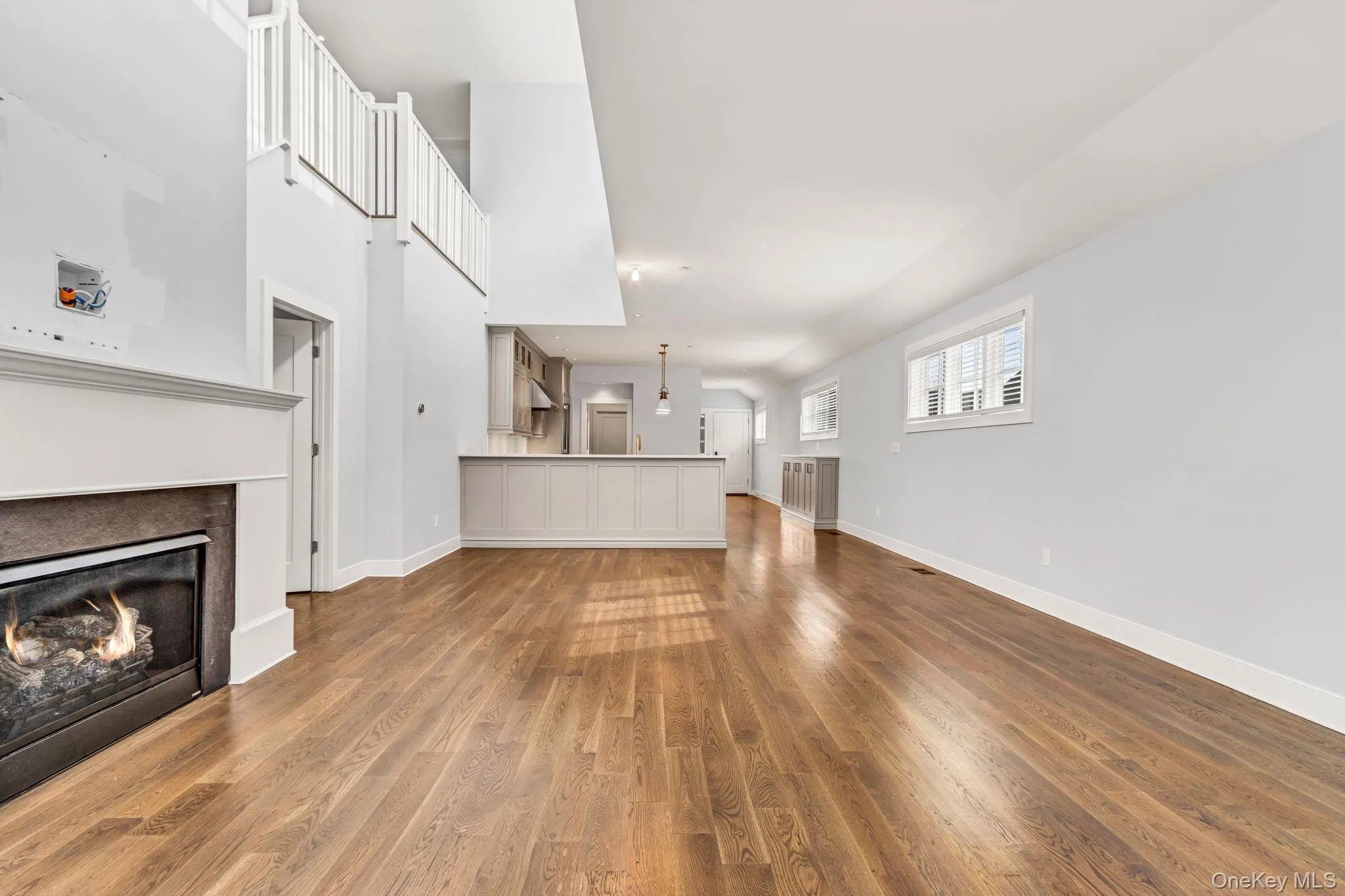 Unfurnished living room featuring a glass covered fireplace and dark wood-style flooring Unfurnished living room featuring a glass covered fireplace and dark wood-style flooring