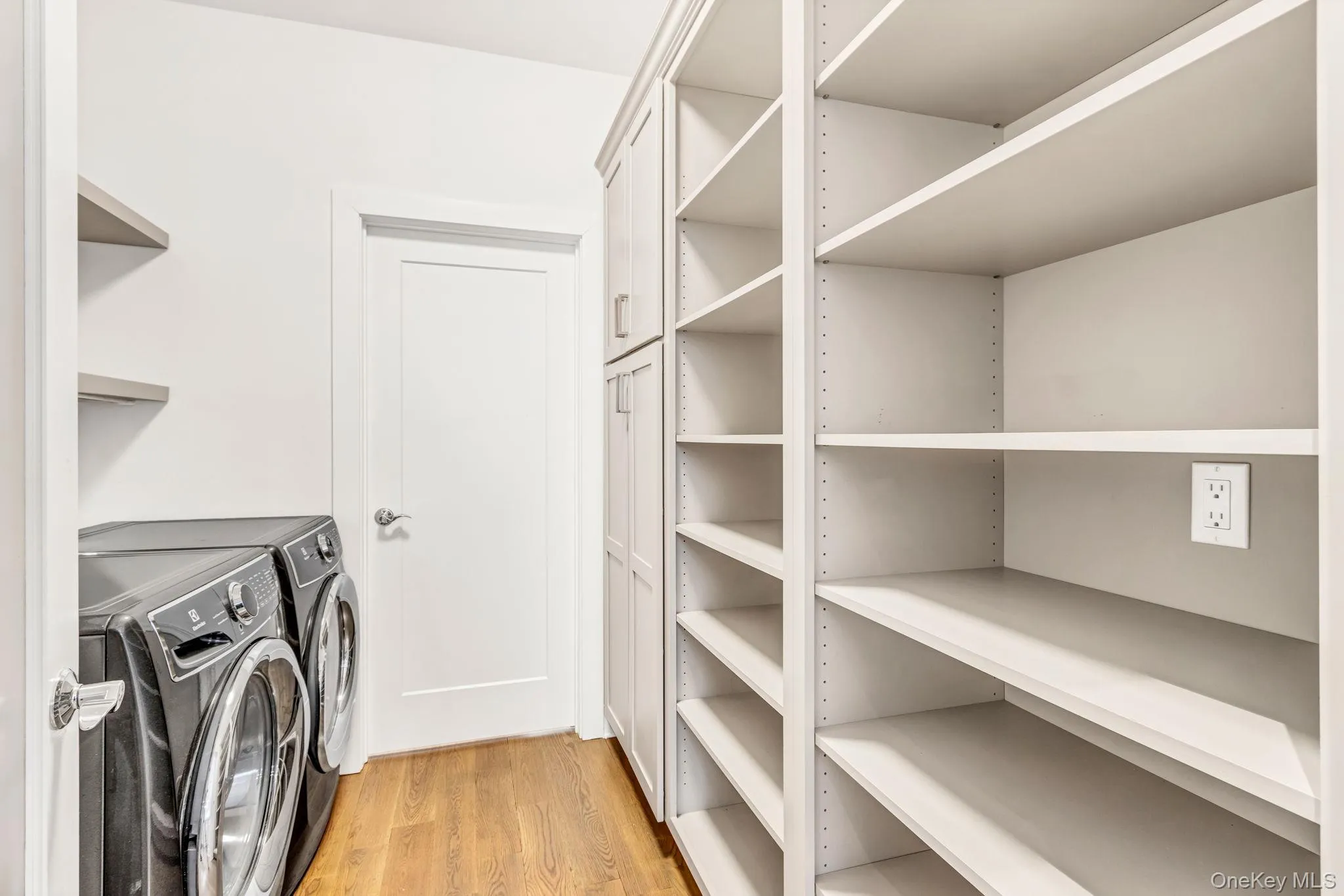 Laundry area featuring light wood-style floors and washer and dryer Laundry area featuring light wood-style floors and washer and dryer