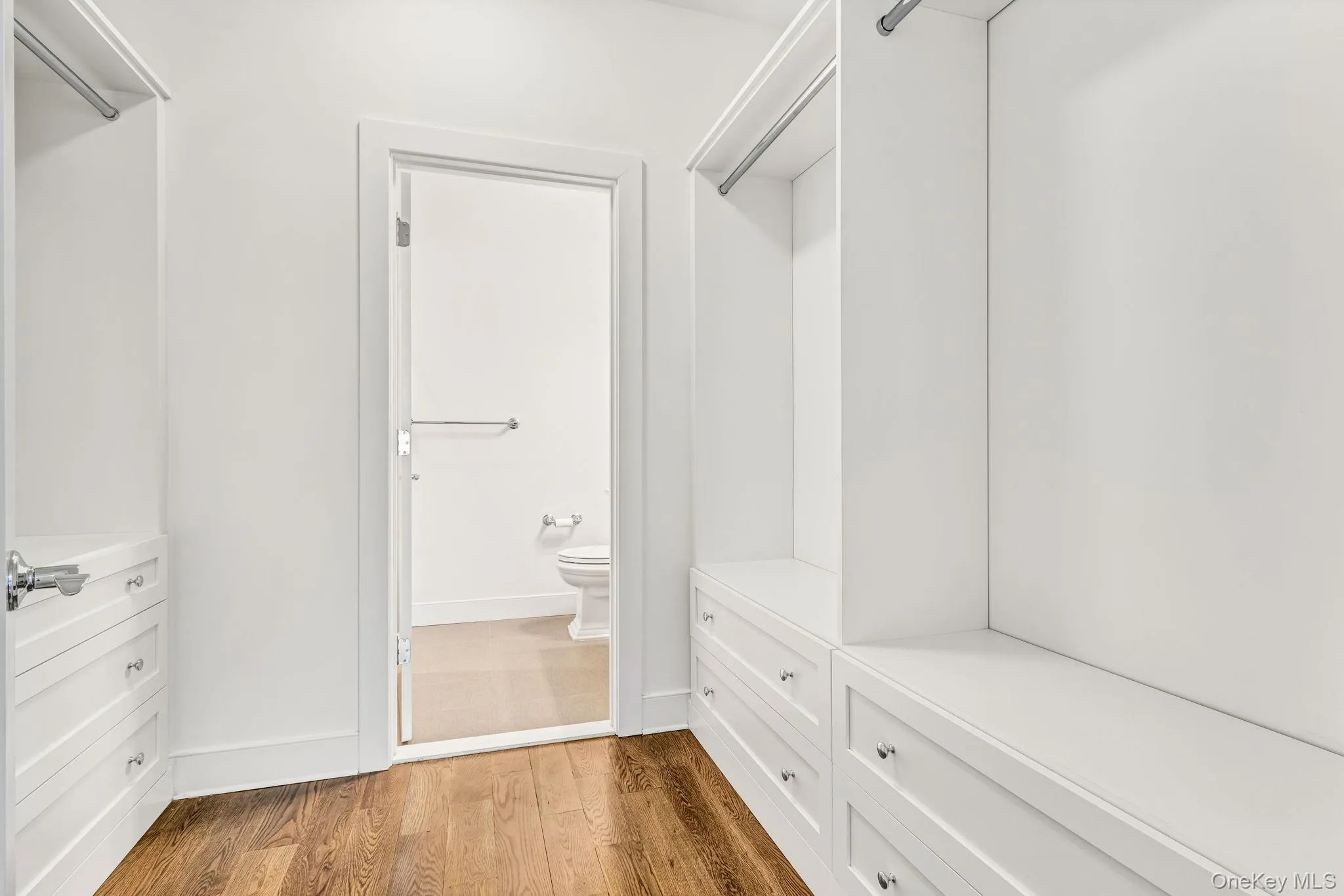 Spacious closet with light wood-type flooring Spacious closet with light wood-type flooring