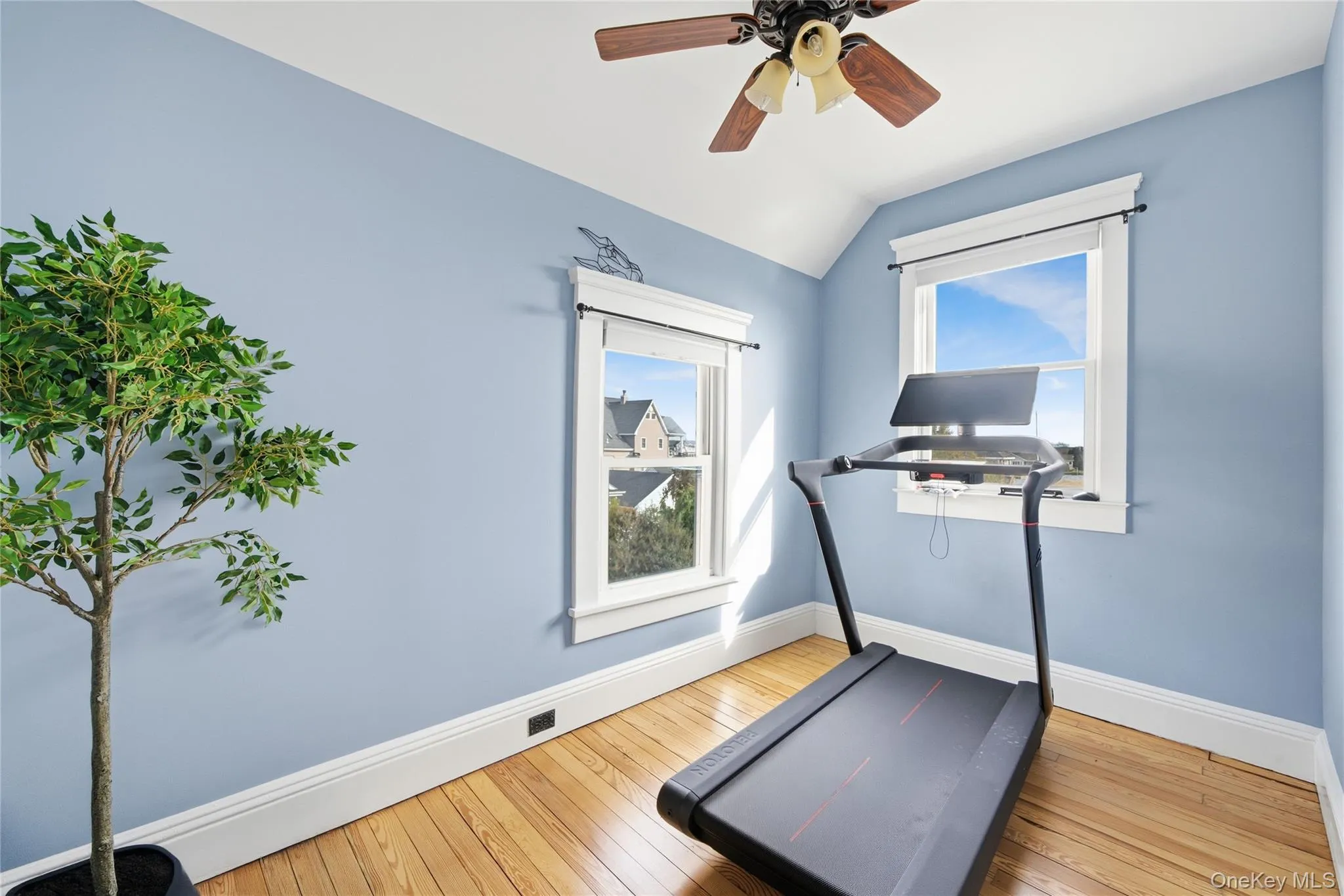 Exercise area featuring light wood-style floors, vaulted ceiling, and ceiling fan Exercise area featuring light wood-style floors, vaulted ceiling, and ceiling fan