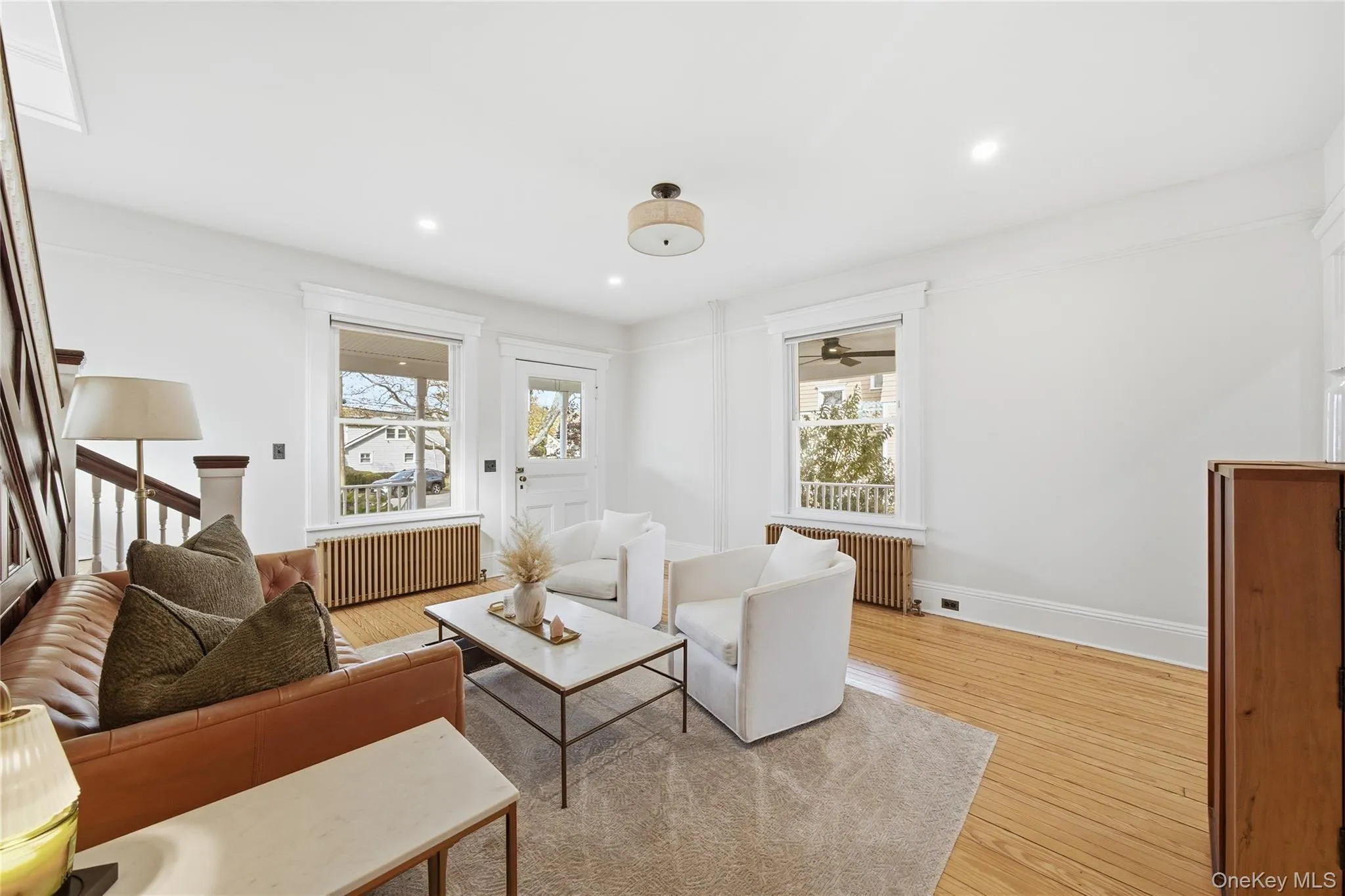 Living area featuring light wood-style floors, radiator, and recessed lighting Living area featuring light wood-style floors, radiator, and recessed lighting