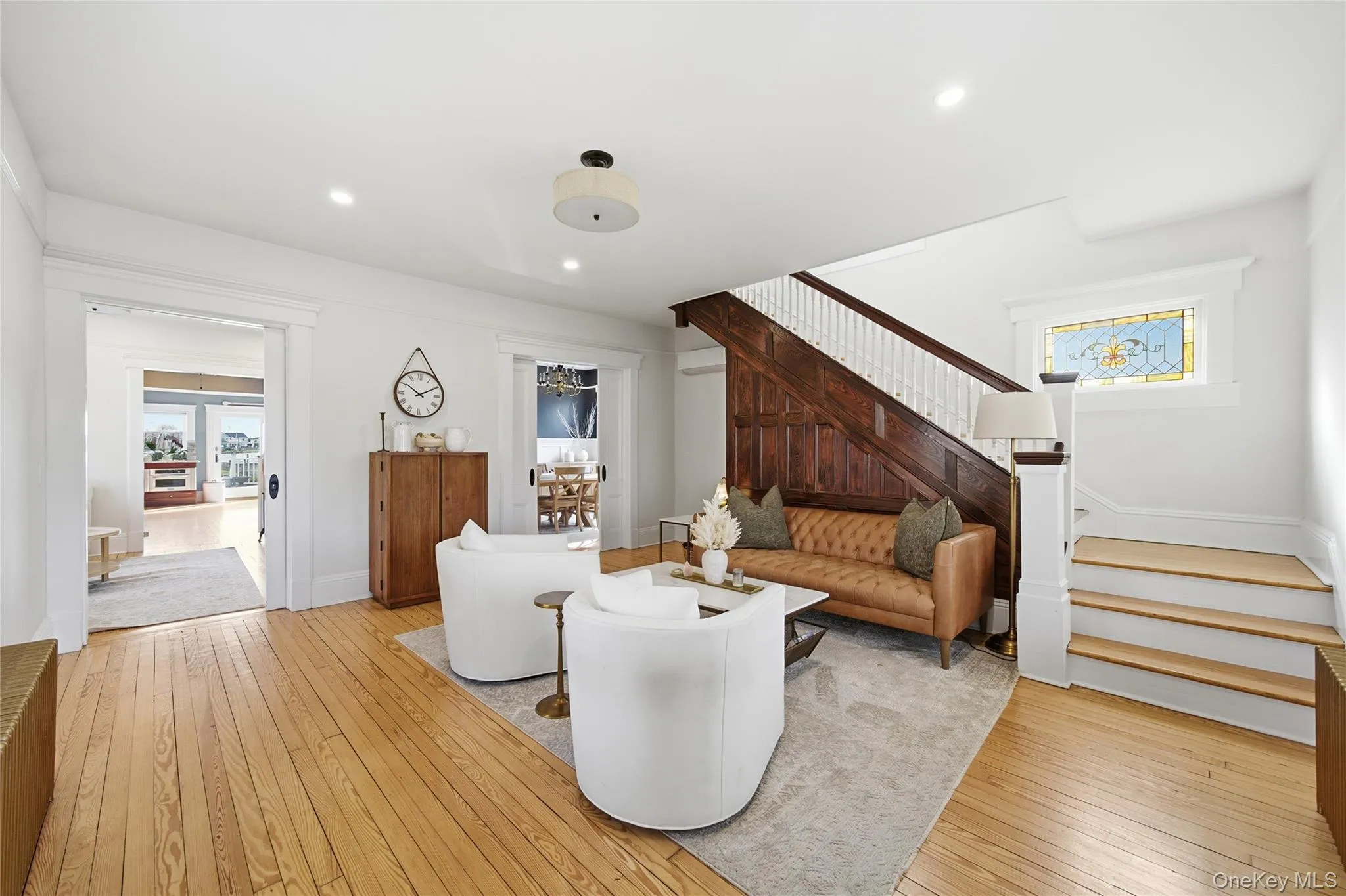 Living room with plenty of natural light, light wood finished floors, stairs, and recessed lighting Living room with plenty of natural light, light wood finished floors, stairs, and recessed lighting