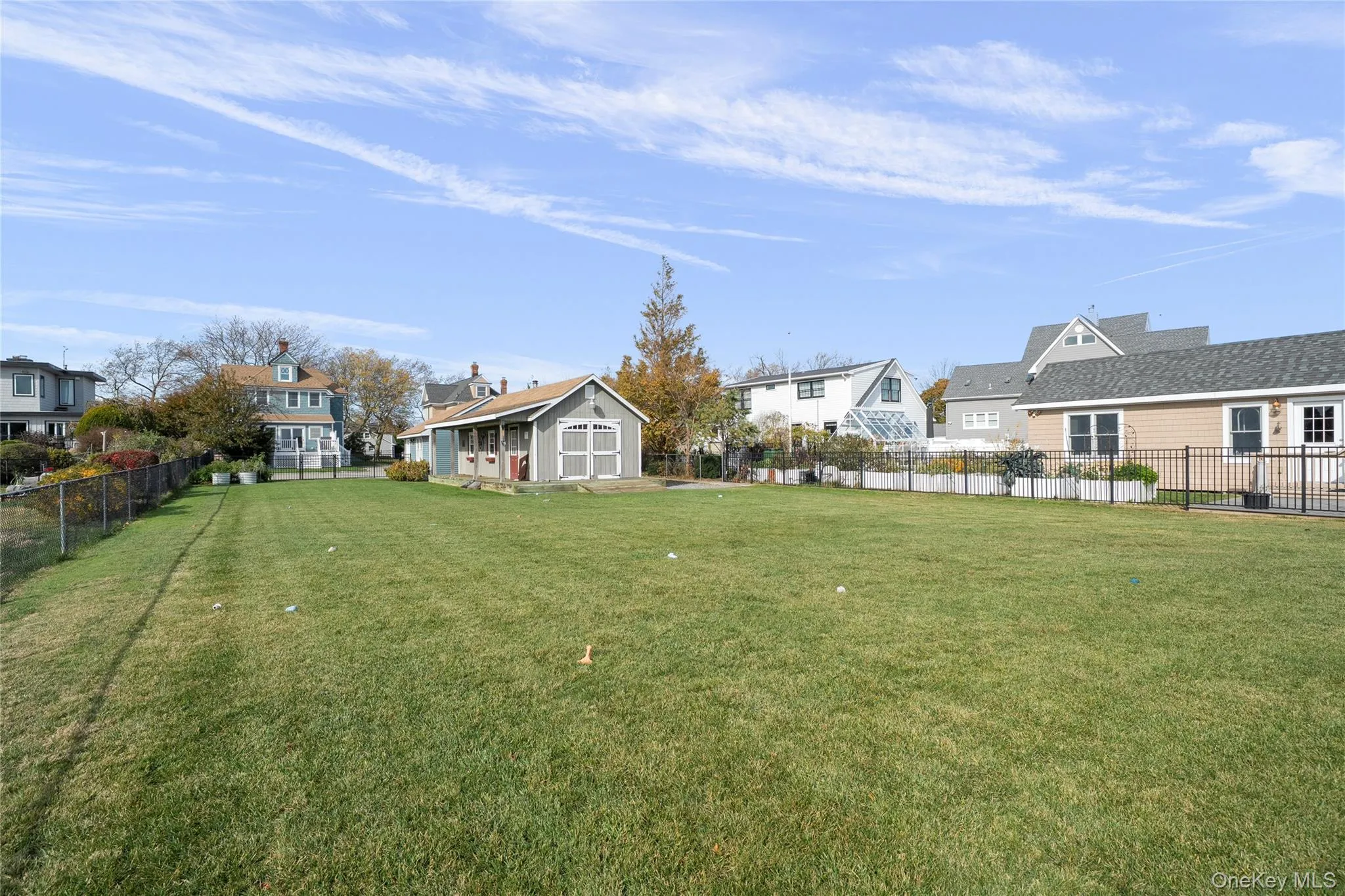 Fenced backyard featuring a residential view and an outbuilding Fenced backyard featuring a residential view and an outbuilding