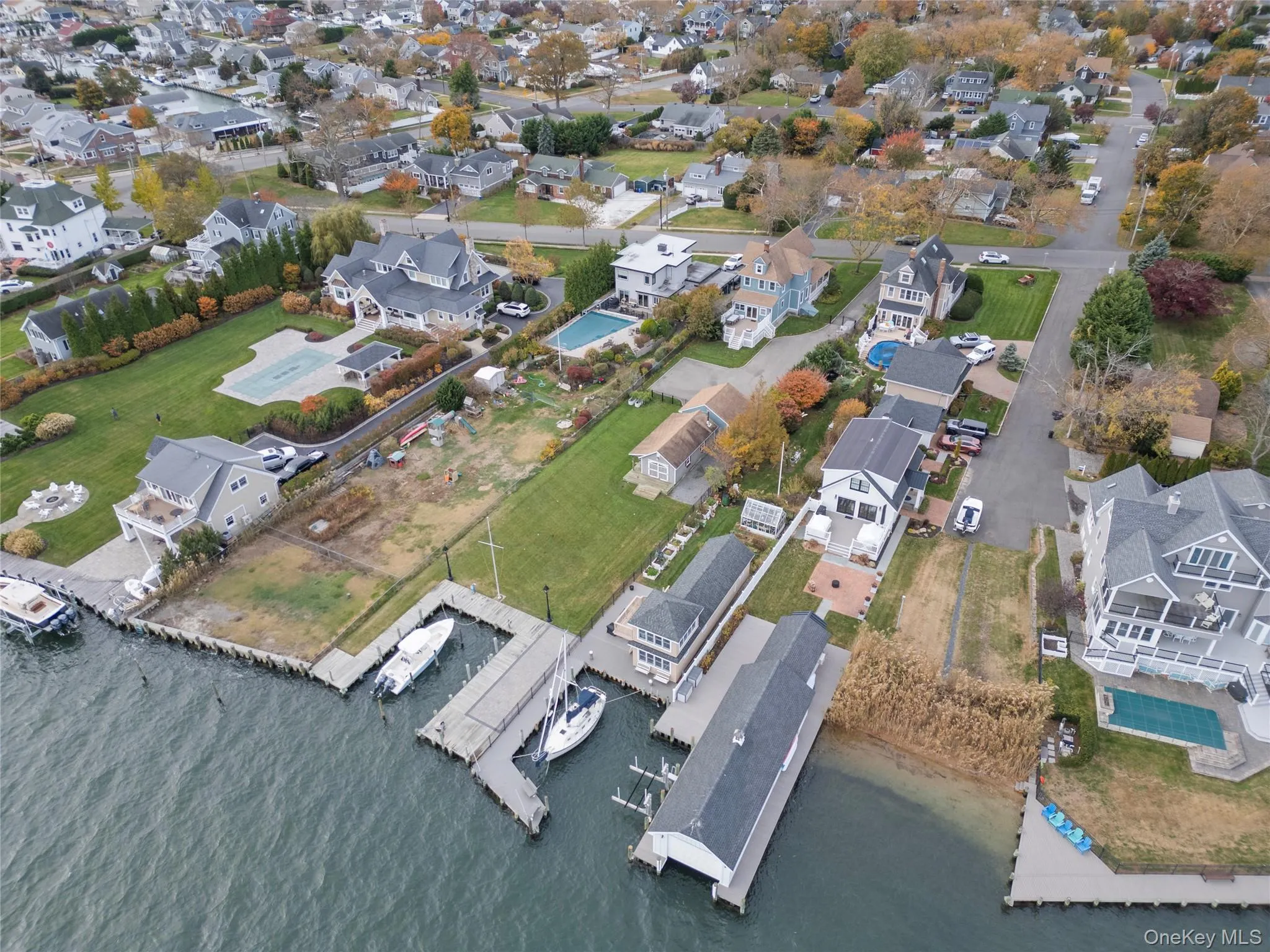 Aerial view of property's location featuring nearby suburban area and a large body of water Aerial view of property's location featuring nearby suburban area and a large body of water