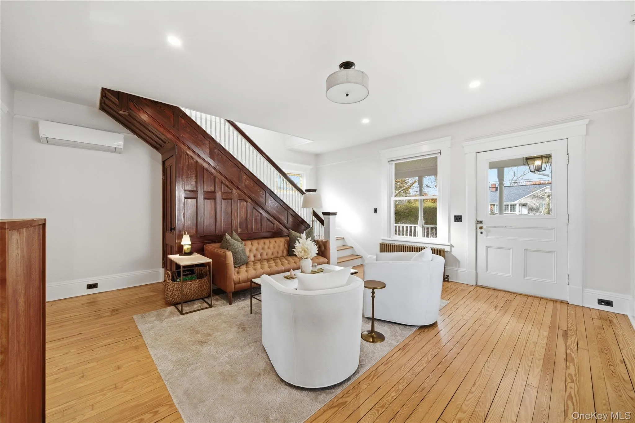 Living room featuring light wood finished floors, a wall mounted AC, recessed lighting, and stairway Living room featuring light wood finished floors, a wall mounted AC, recessed lighting, and stairway