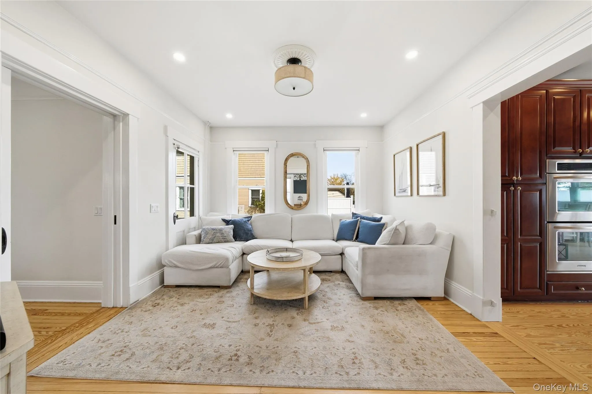 Living area with light wood-style flooring, plenty of natural light, and recessed lighting Living area with light wood-style flooring, plenty of natural light, and recessed lighting
