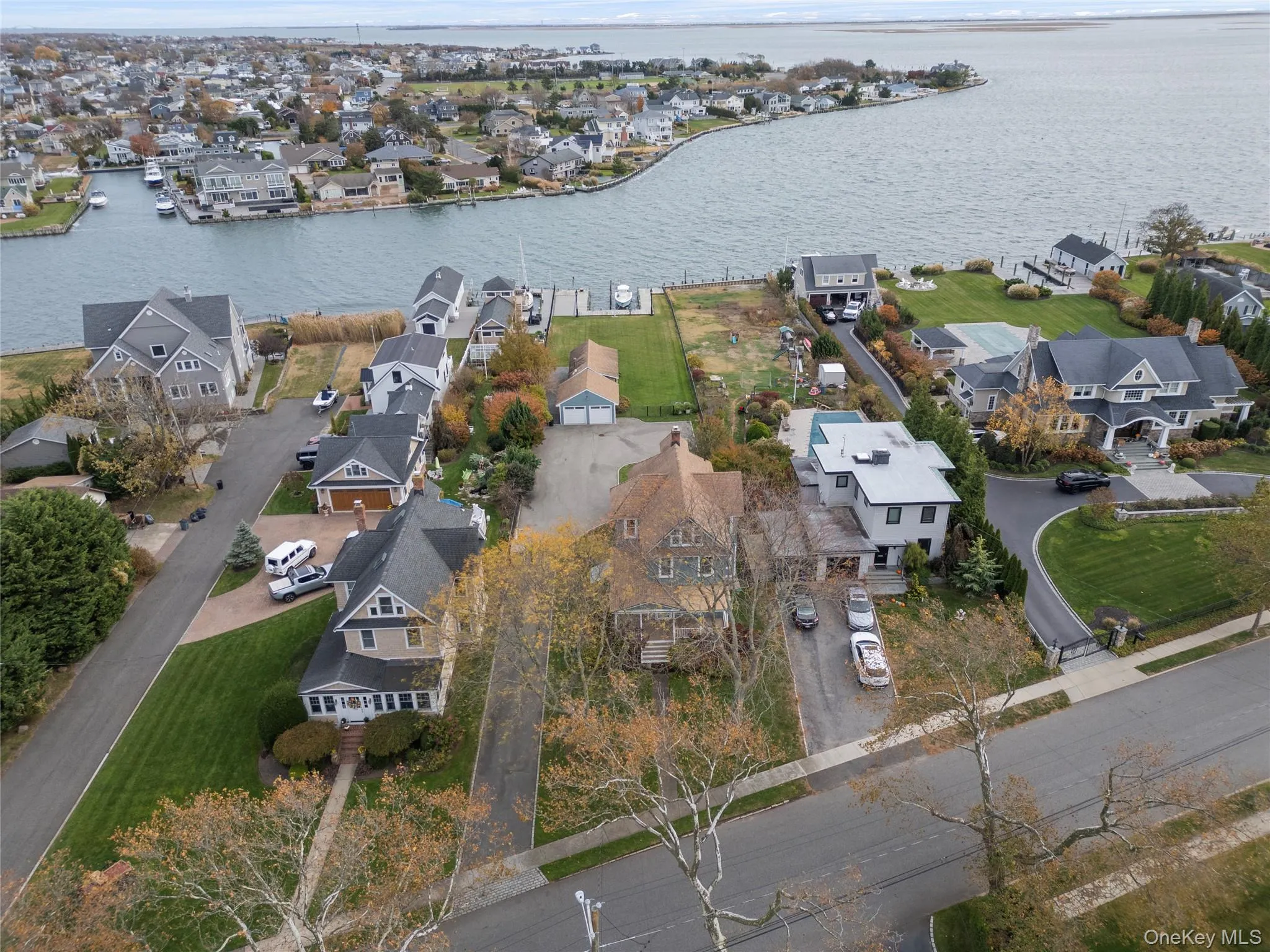 Aerial view of property and surrounding area featuring nearby suburban area and a large body of water Aerial view of property and surrounding area featuring nearby suburban area and a large body of water