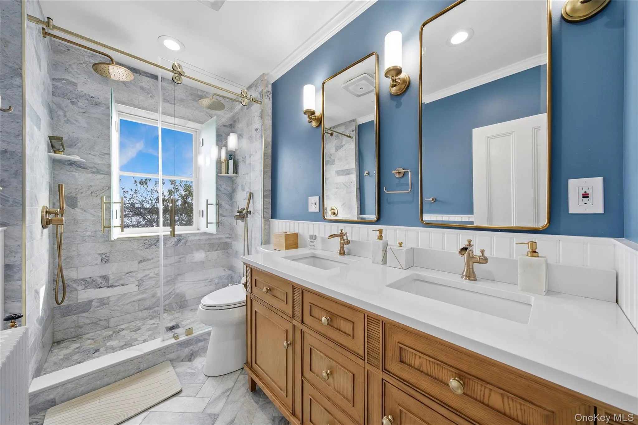Full bath featuring crown molding, double vanity, a marble finish shower, wainscoting, and recessed lighting Full bath featuring crown molding, double vanity, a marble finish shower, wainscoting, and recessed lighting