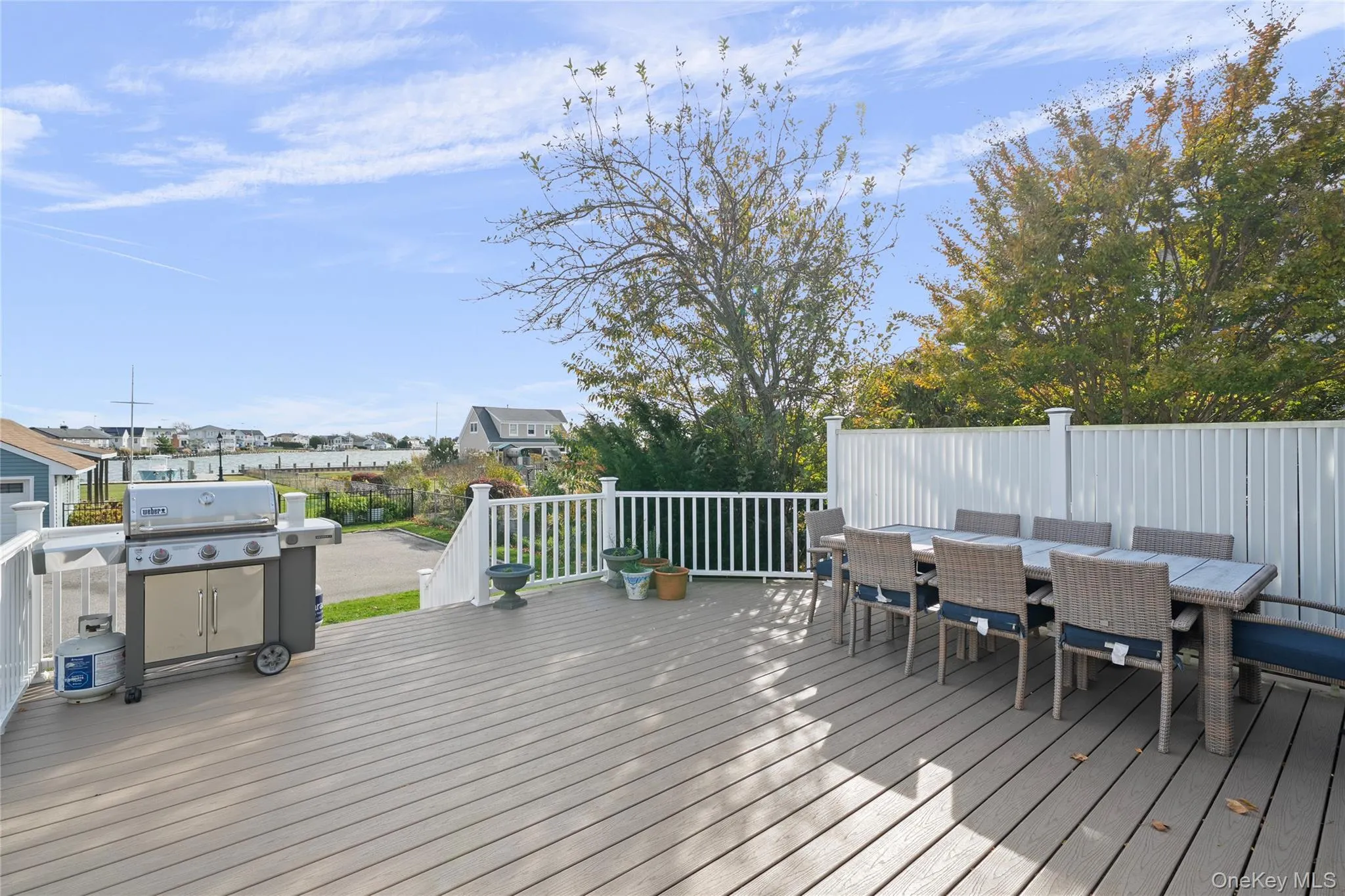 Wooden deck with a residential view, outdoor dining area, and grilling area Wooden deck with a residential view, outdoor dining area, and grilling area