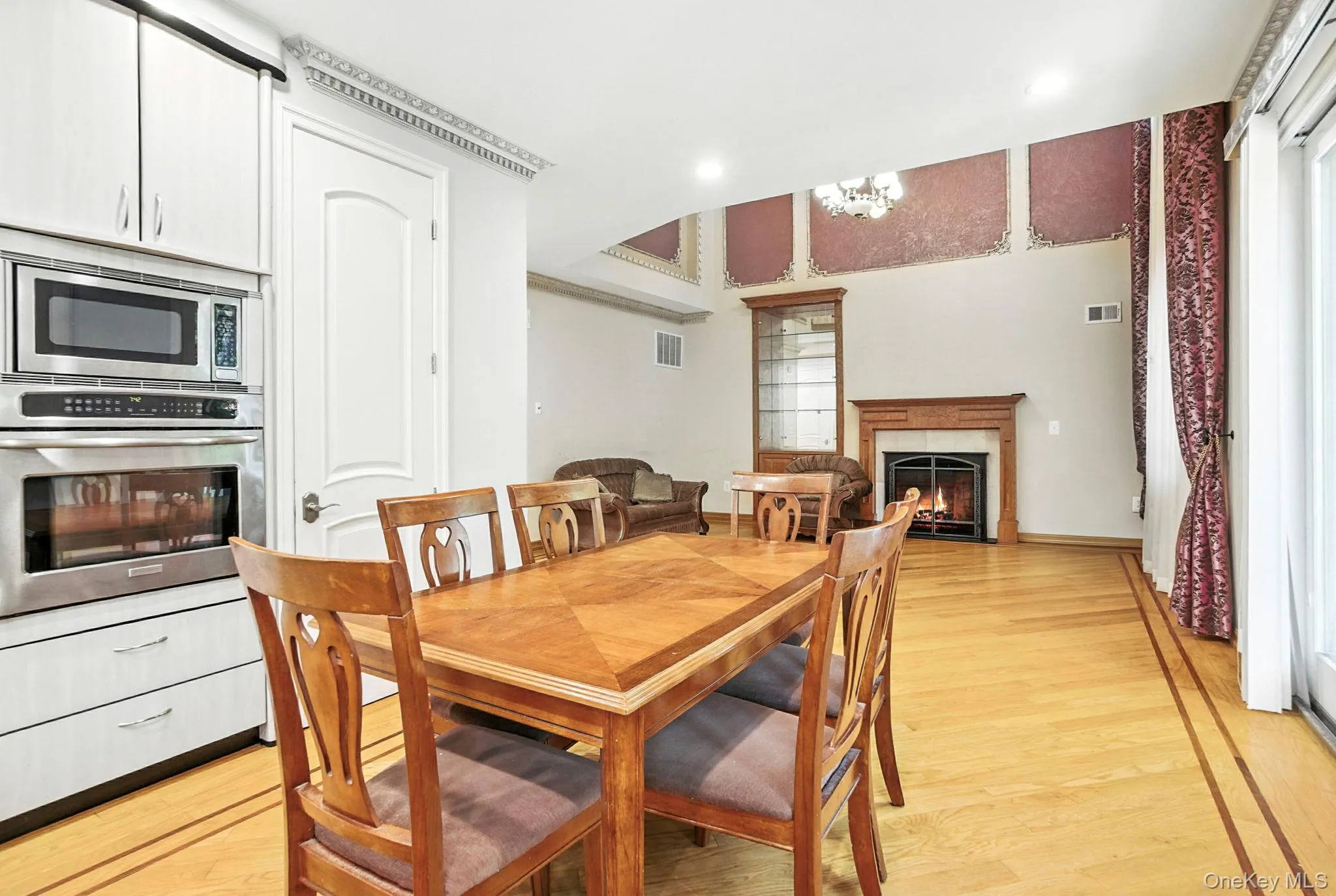 Dining room featuring light wood-type flooring, a high end fireplace, a chandelier, and recessed lighting Dining room featuring light wood-type flooring, a high end fireplace, a chandelier, and recessed lighting