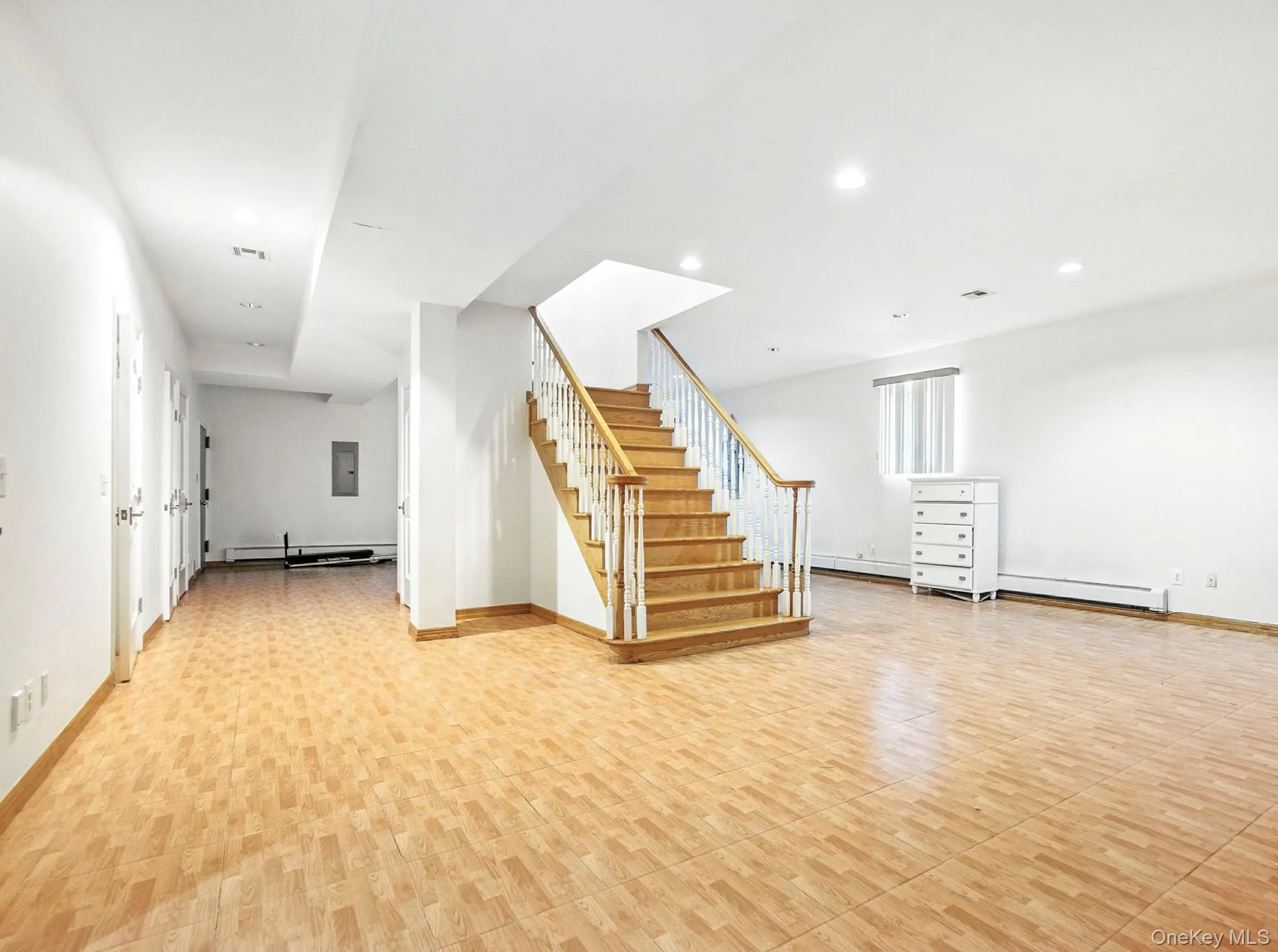 Below grade area with stairway, recessed lighting, baseboard heating, and electric panel Below grade area with stairway, recessed lighting, baseboard heating, and electric panel