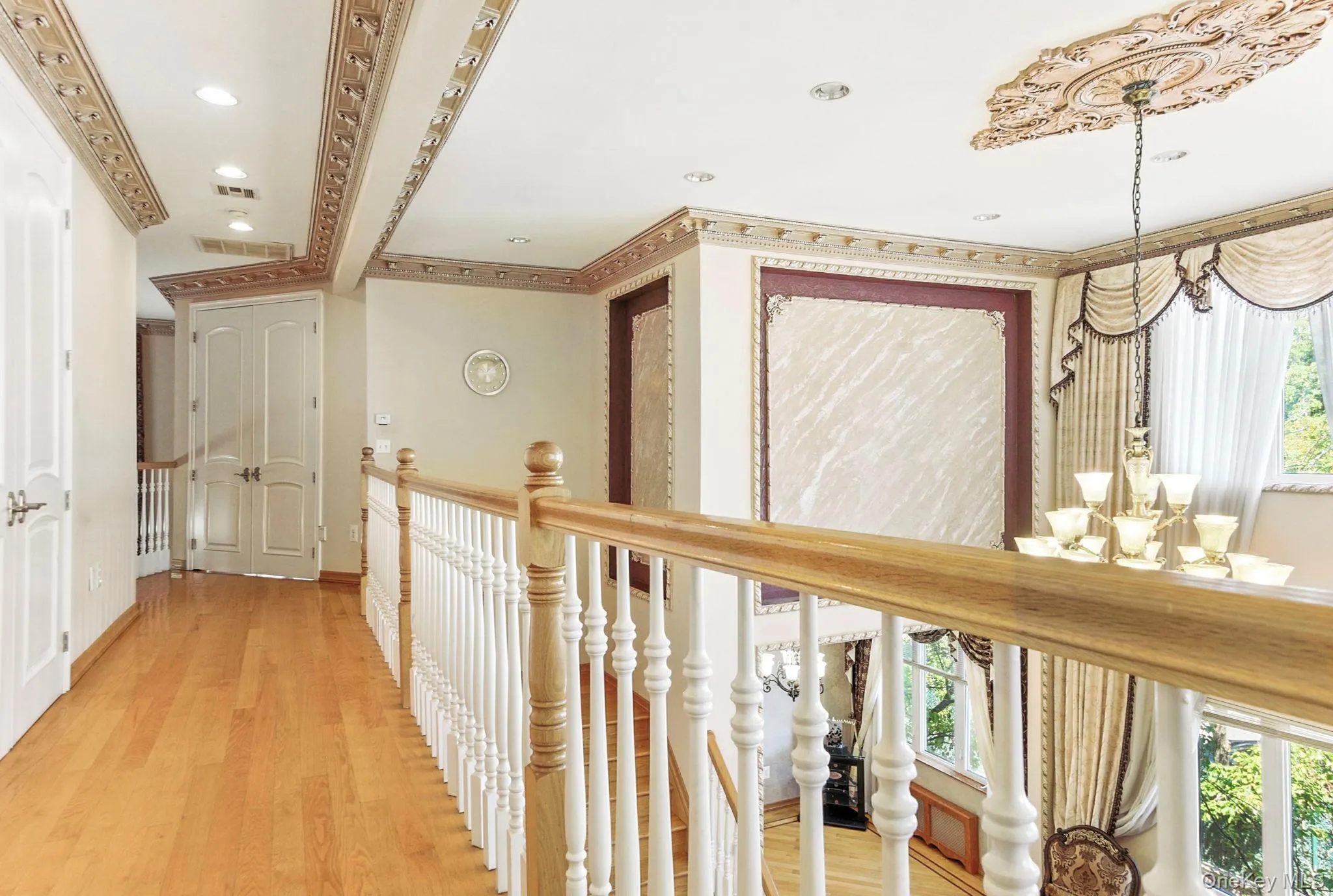 Hall featuring a chandelier, light wood finished floors, crown molding, and recessed lighting Hall featuring a chandelier, light wood finished floors, crown molding, and recessed lighting