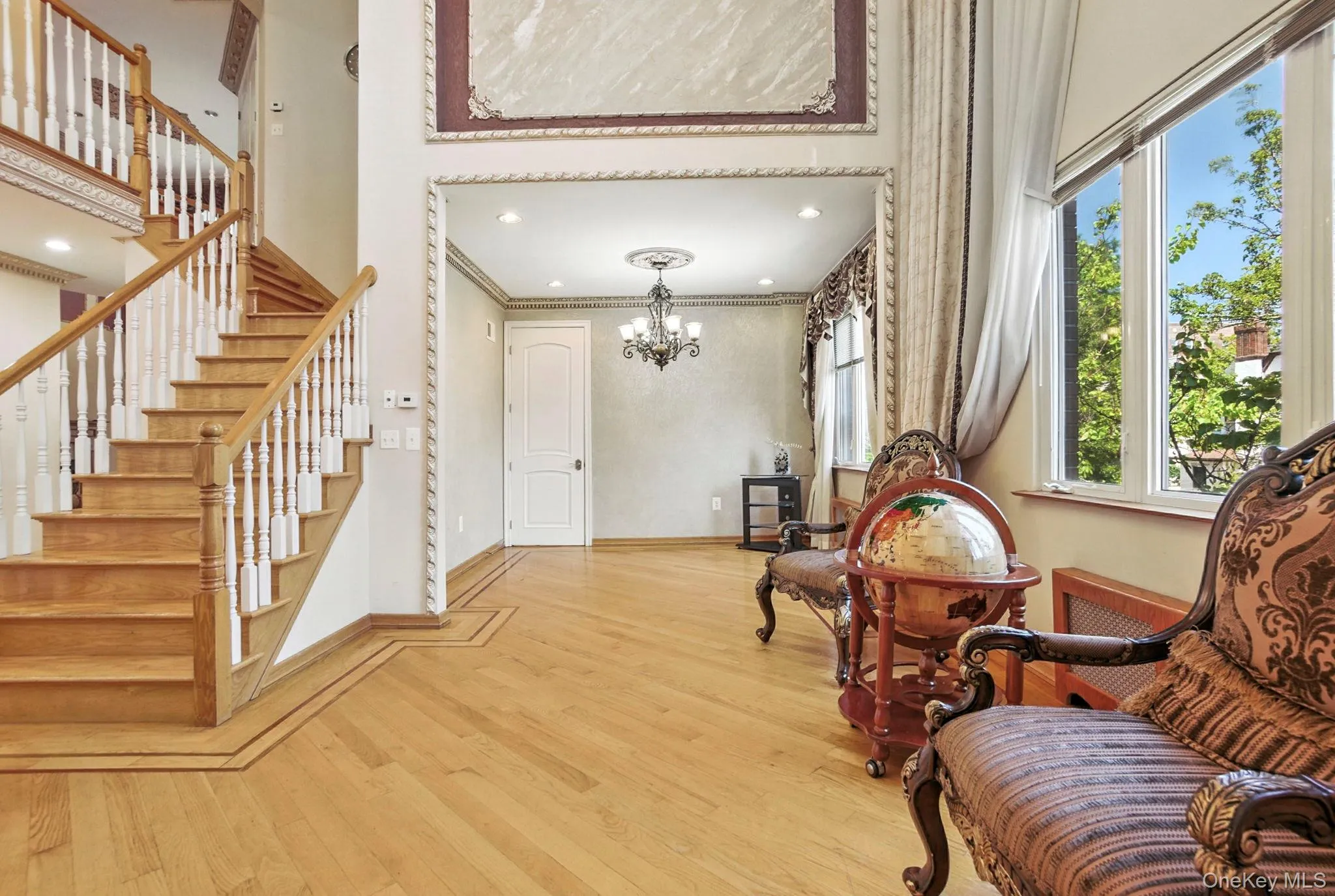 Sitting room with light wood finished floors, crown molding, stairway, a chandelier, and recessed lighting Sitting room with light wood finished floors, crown molding, stairway, a chandelier, and recessed lighting